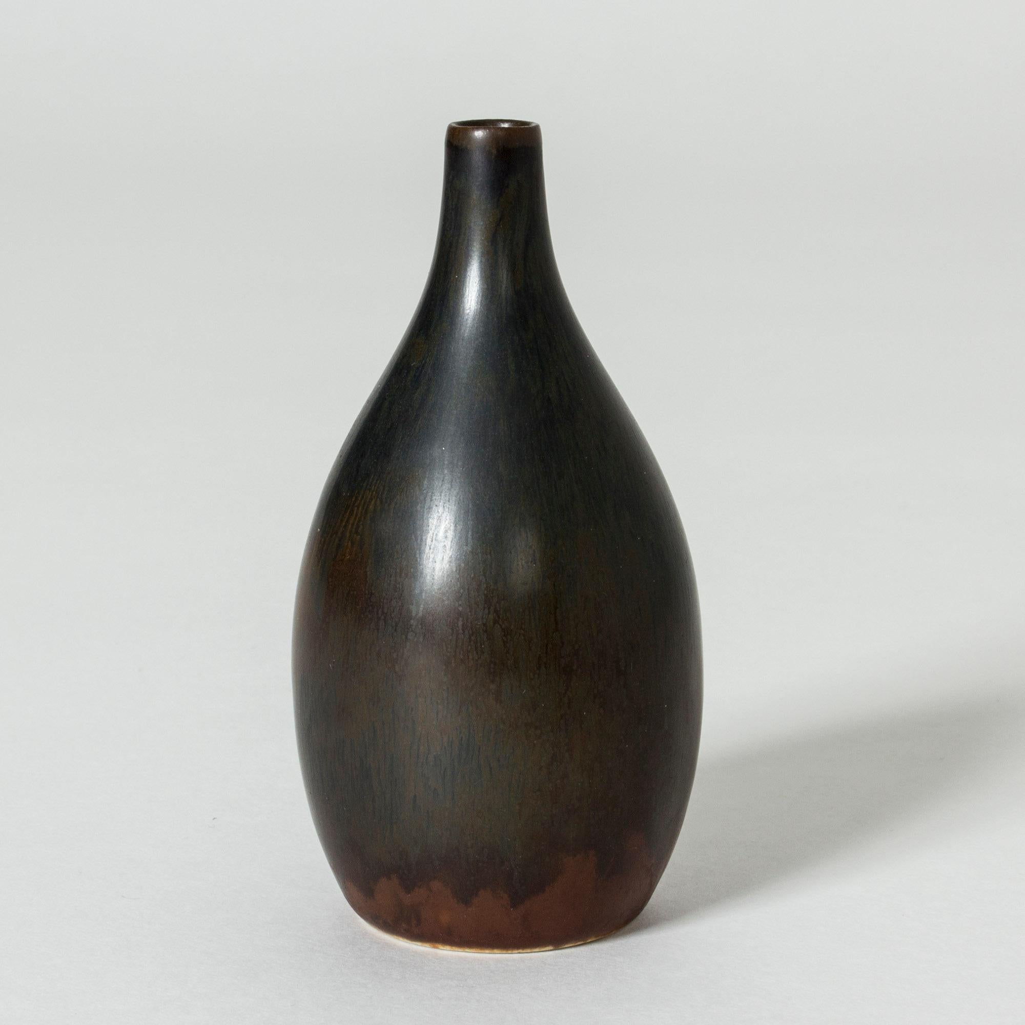 Cool, small stoneware vase by Carl-Harry Stålhane in a smooth, organic shape. Black glaze over rusty brown.