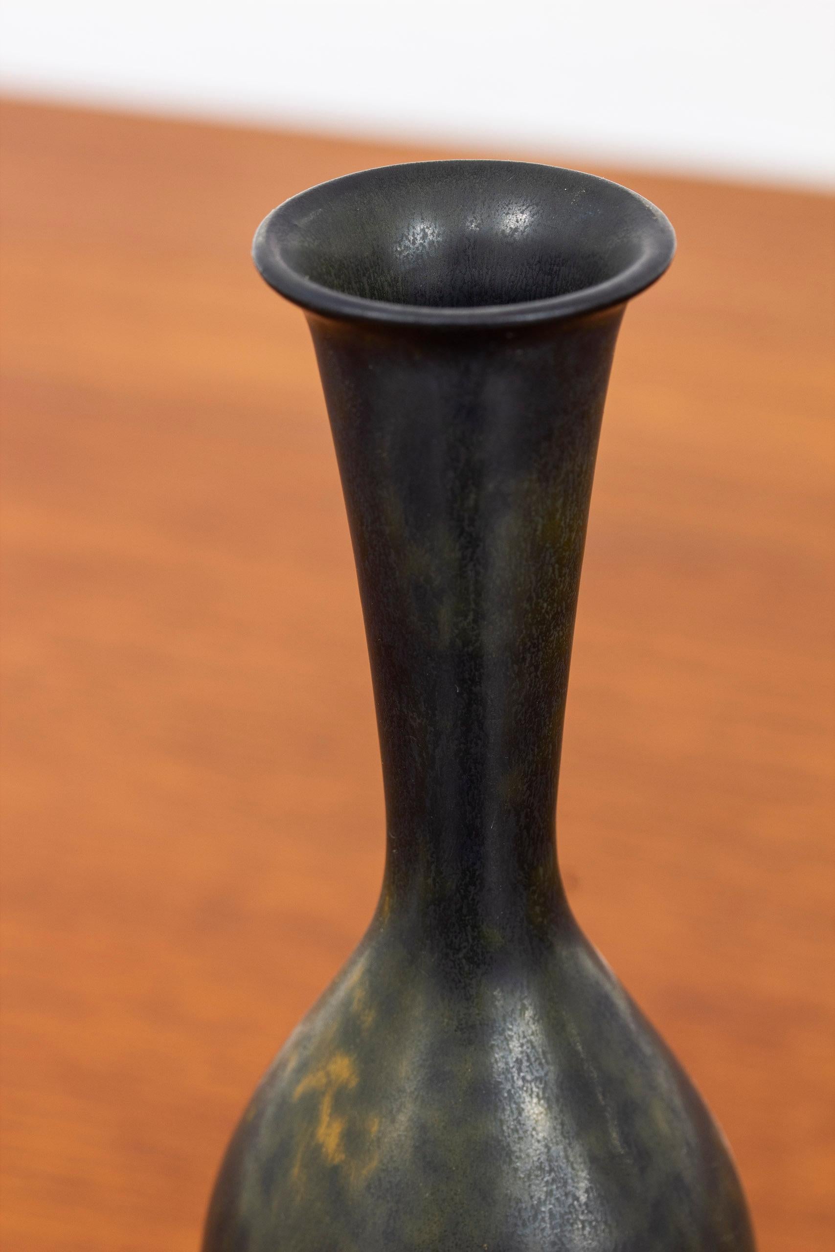 Stoneware vase designed by Gunnar Nylund. Hand made at Rörstrand in the 1940s. With black glaze with hints of green. Very good vintage condition with light wear and patina.

Dimensions: Ø. 6 H. 24 cm.


