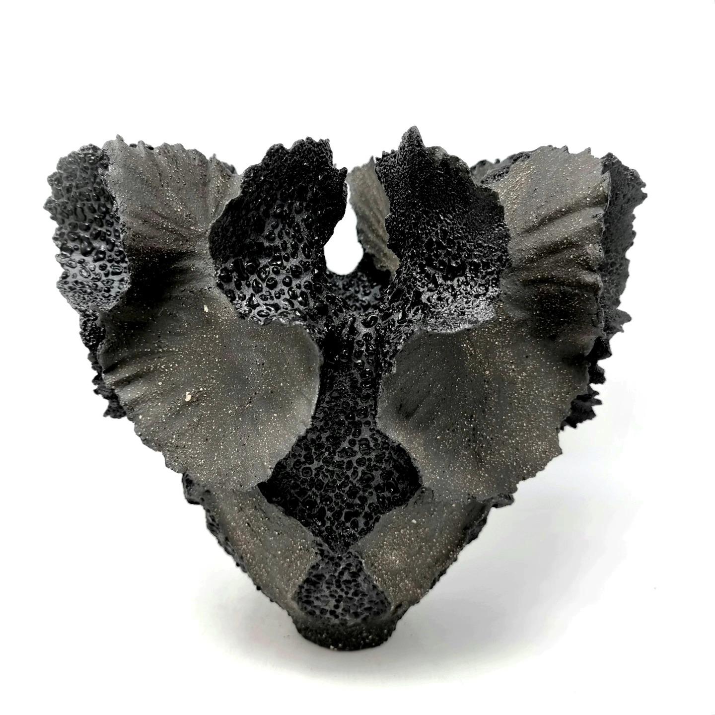 Handbuilt Stonewear Sculpture in black stonewear clay

It is sculpted by hand, slowly adding coils and clay to create the final result. This is a piece of art based on classic sculpting methods. 
 
On the inside the piece is glazed with black