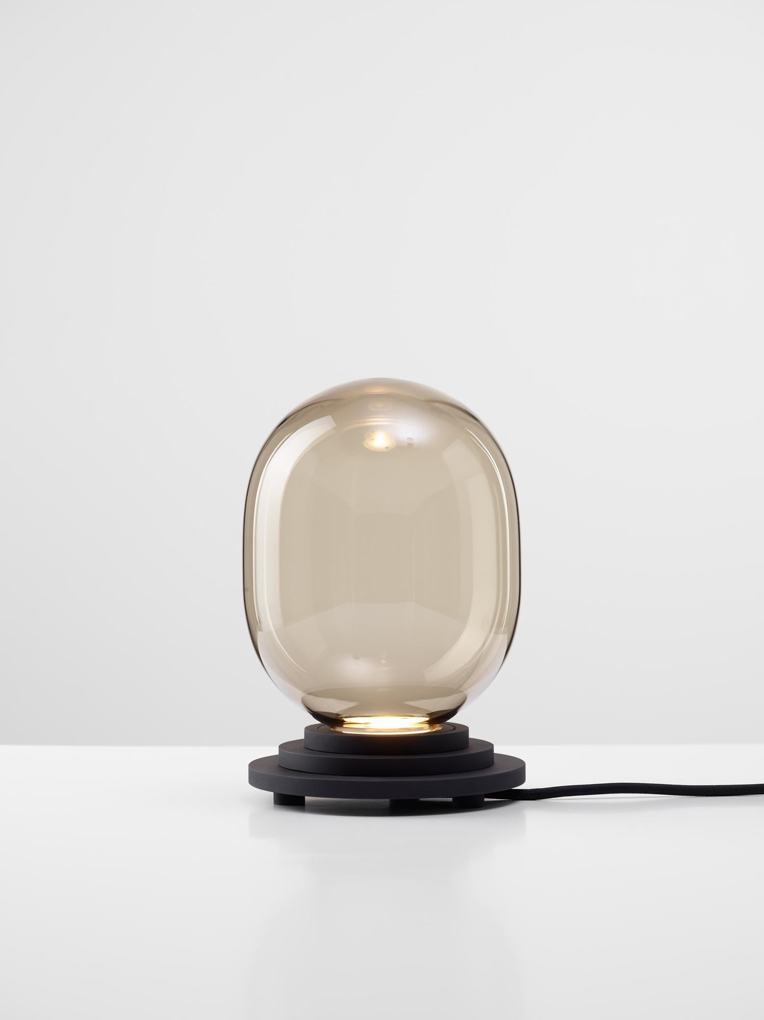Black Stratos capsule table light by Dechem Studio
Dimensions: D 15 x H 22 cm
Materials: Aluminum, glass.
Also available: Different colours available,

Different shapes of capsules and spheres contrast with anodized alloy fixtures, creating a