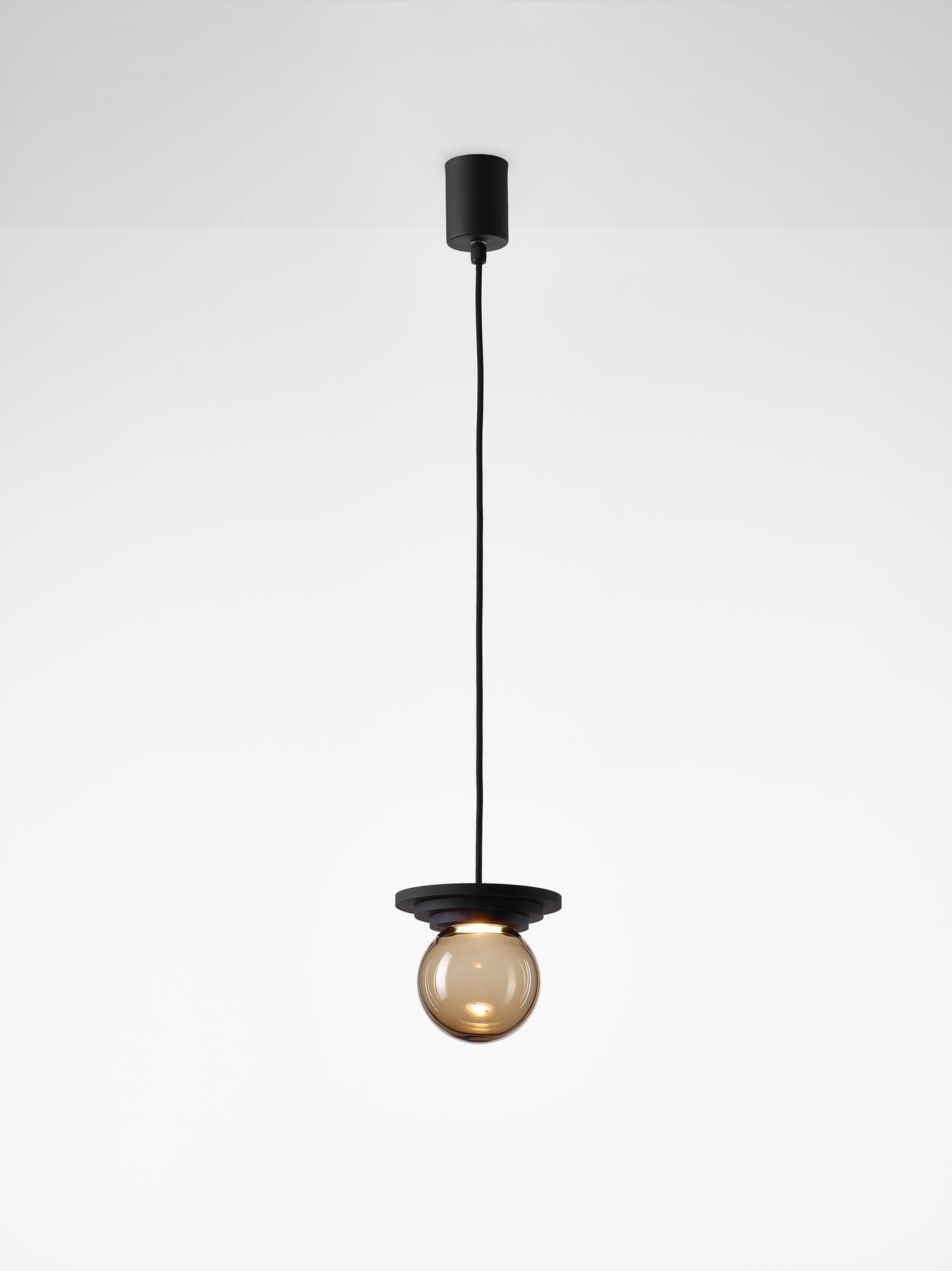 Black Stratos mini ball pendant light by Dechem Studio.
Dimensions: D 12 x H 14 cm.
Materials: aluminum, glass.
Also available: different colours available.

Different shapes of capsules and spheres contrast with anodized alloy fixtures,