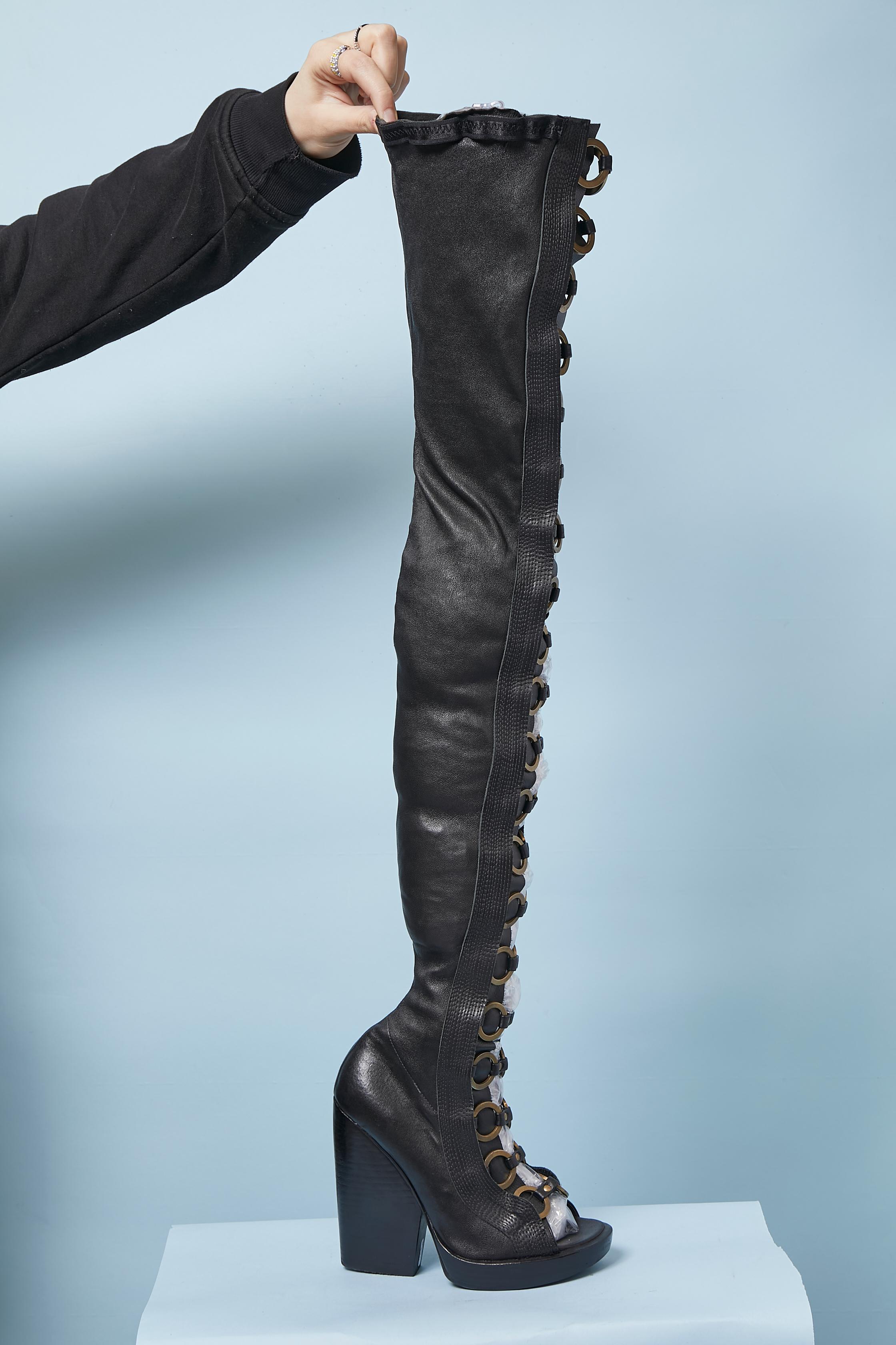 Black stretch leather high boots open toe with metal ring. Zip closure on the inside side of the legs.
Boots height : 80cm
Plateforme height: 2,5cm
Heel height: 13cm
SIZE 36 1/2
There is a brand name but impossible to read.