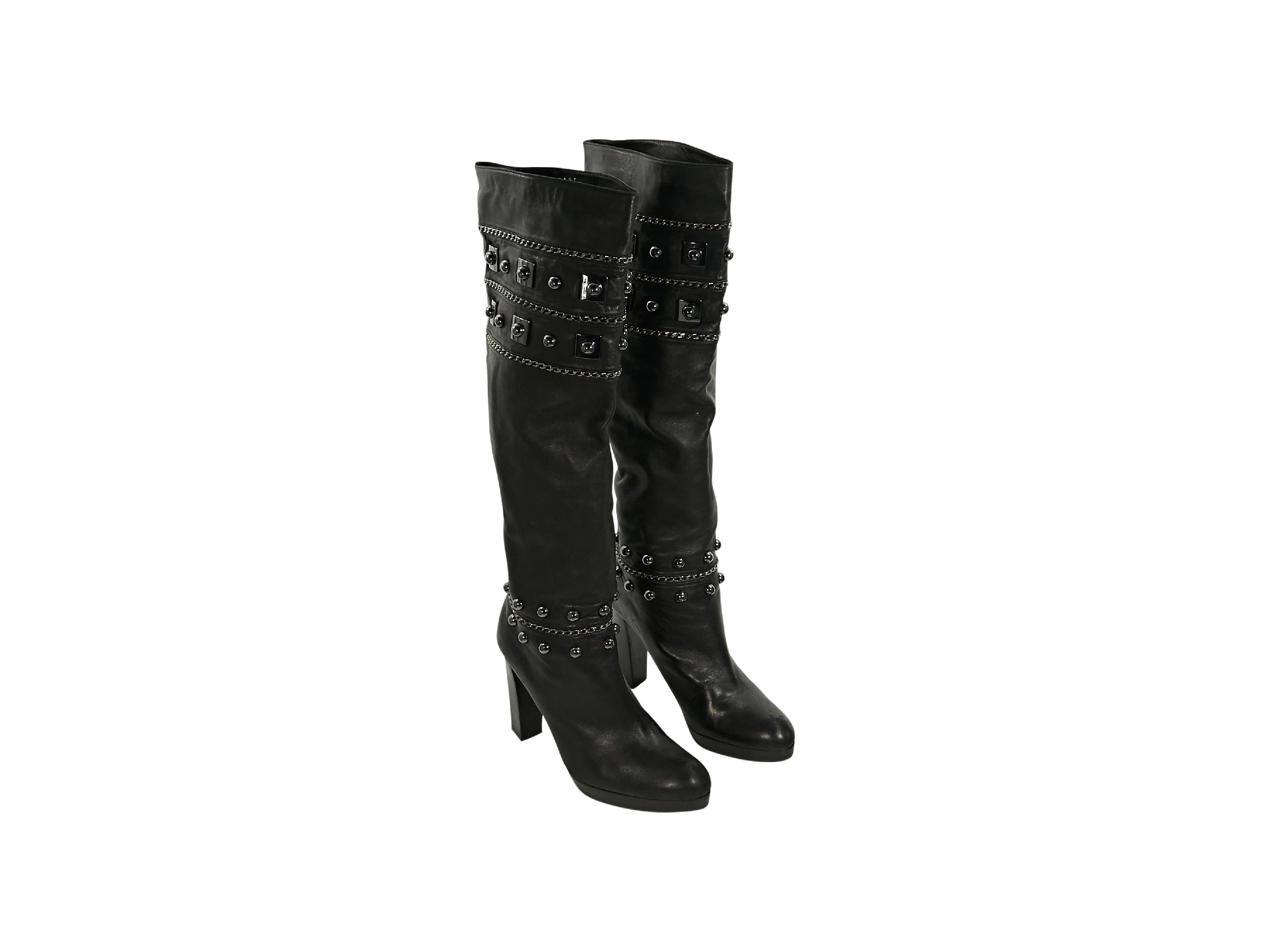 Product details:  Black leather heeled boots by Stuart Weitzman.  Accented with chains and studs.  Round toe.  Stacked heel and platform design.  Gunmetal-tone hardware.  4.25