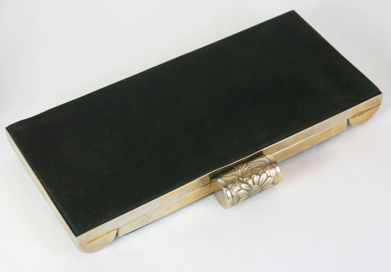 Black Suede and Bakelite Minaudiere from the 1930's. 
Completely outfitted as a vanity case with compartments for every need (from that period). 
The borders of the metal frame and clasp are decorated with hand decorated bakelite clad metal
floral