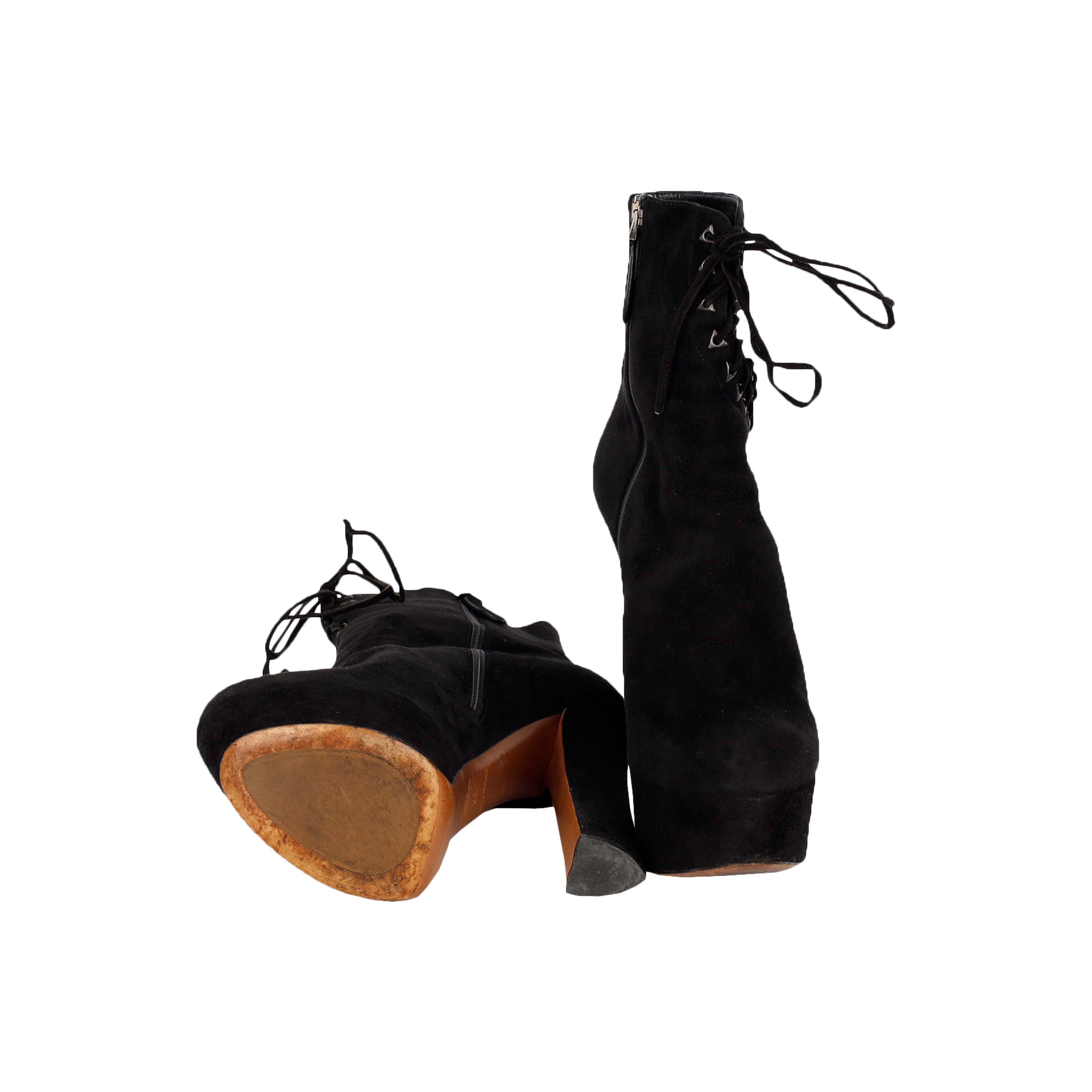 Confectionnées avec soin en daim noir, les bottines Corset à lacets d'Alaïa sont vos indispensables de l'hiver. Les œillets triangulaires rehaussent le chic de ces bottines, et la chaîne en métal armé qui les ferme sur les côtés permet de les