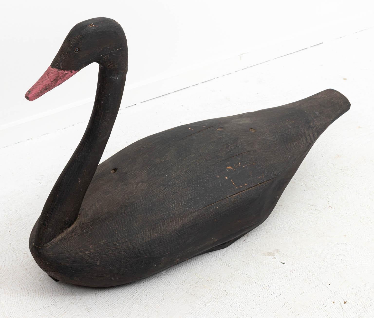 Large black painted swan decoy Folk Art in carved wood. Please note of wear consistent with age including paint loss and minor chips. Made in the United States.