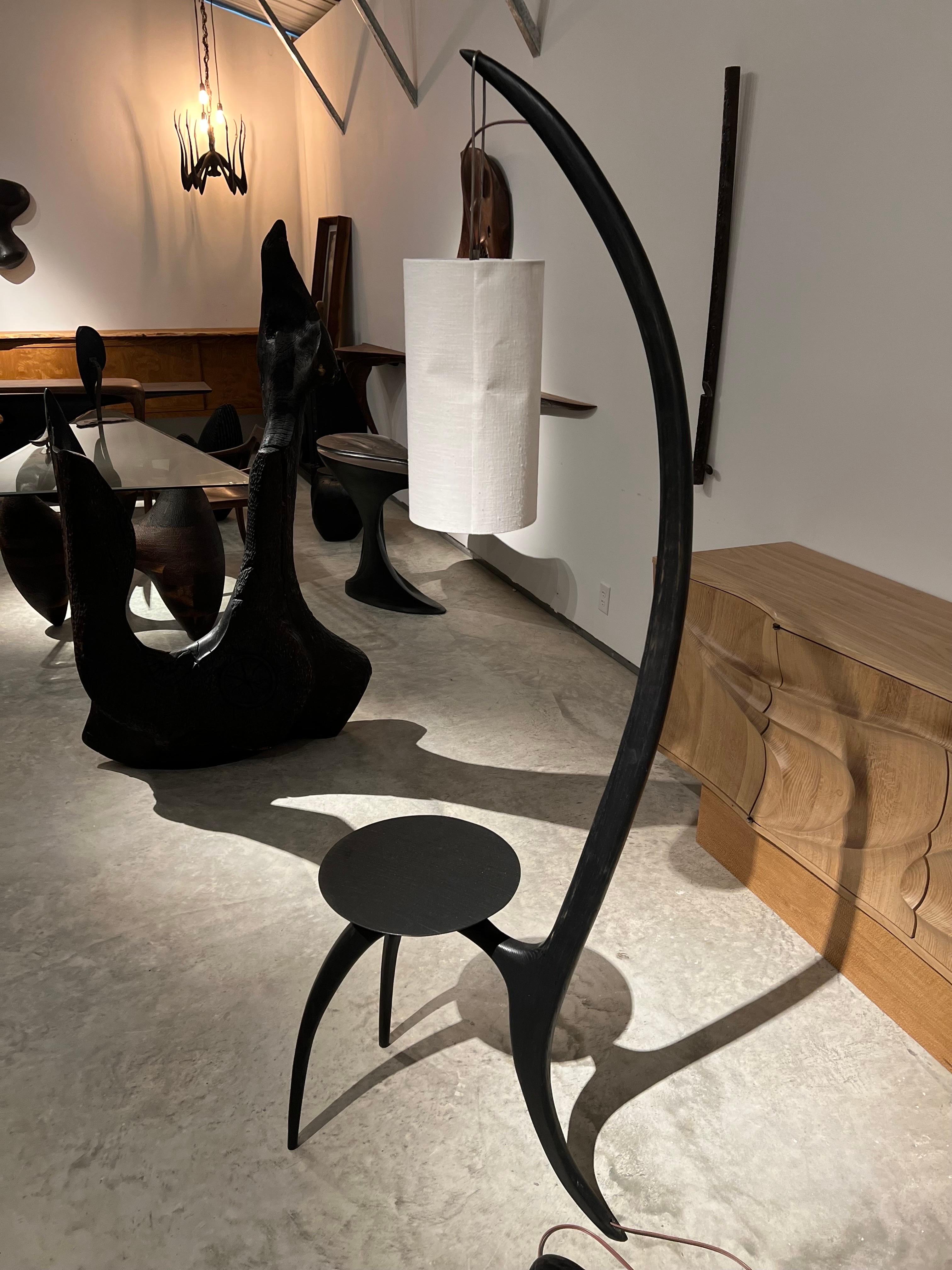 Three legged floor lamp in ebonite’s ash wood with white linen shade