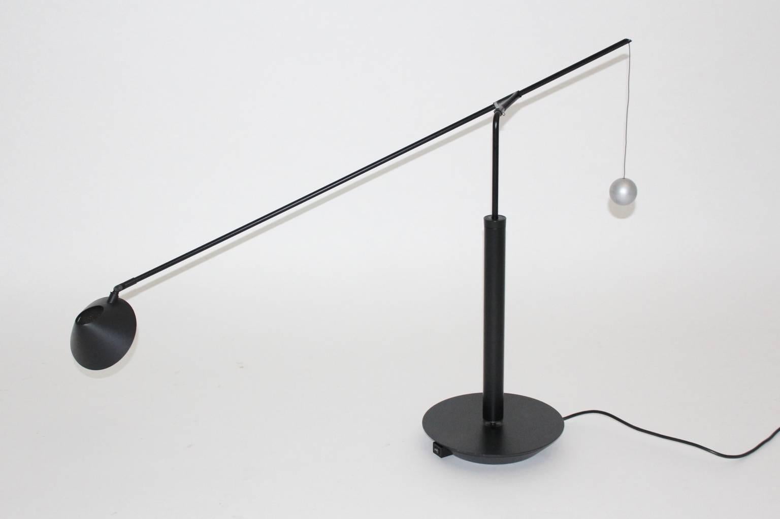 This table lamp was designed by Carlo Forcolini 1989 and executed by Artemide Italy.

The table lamp was made of metal black lacquered and plastic. The metal ball, which features the counterbalance was grey lacquered.
Important to mentioned is, that