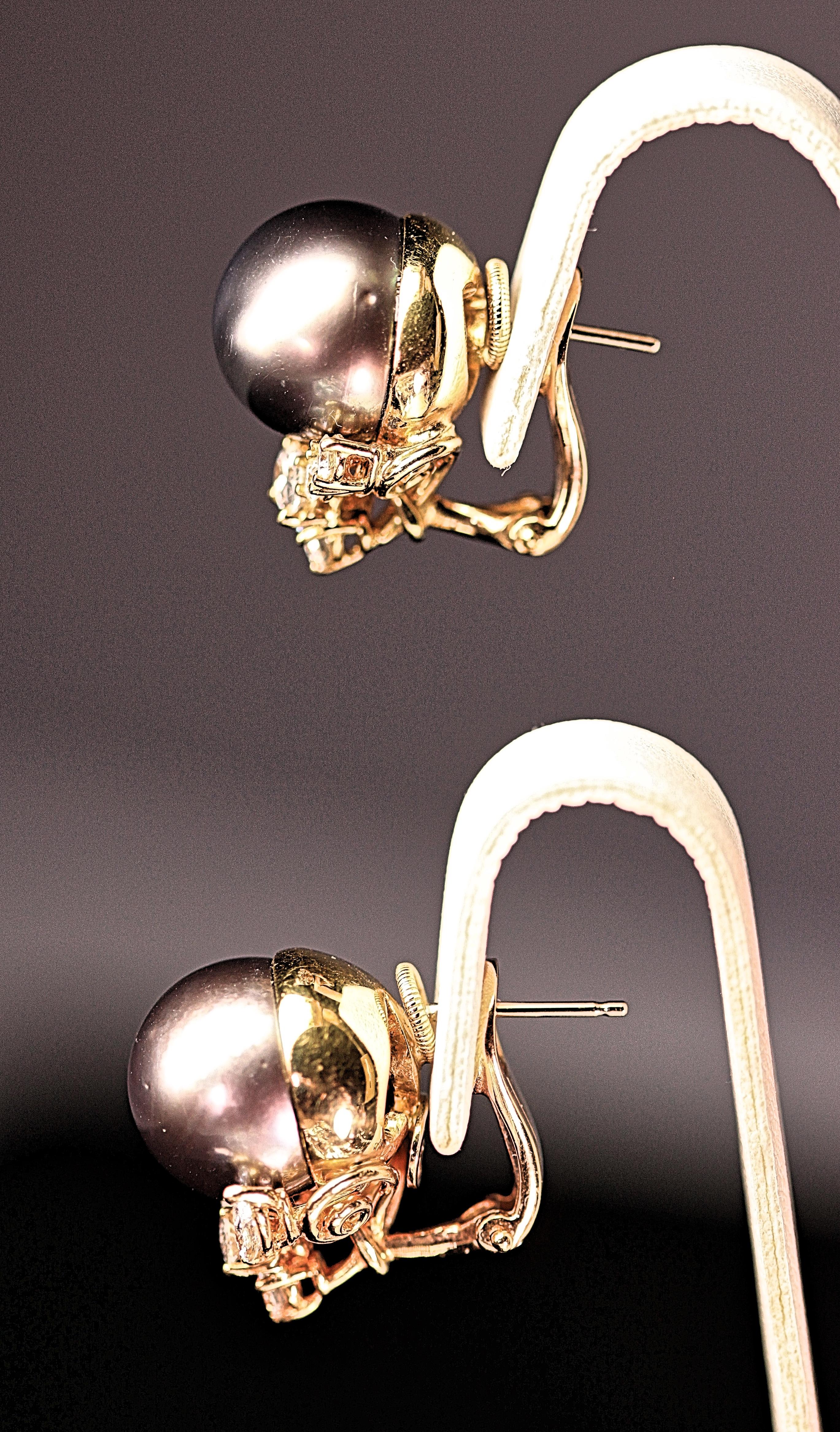 Beautiful black Tahitian 12 mm pearl and diamond earrings by Henry Dunay. The Tahitian pearls measure 12 mm each with minor blemishes and excellent luster. The Tahitian pearls have 5 diamonds below the pearls. The diamond shapes are 2 marquises, 2