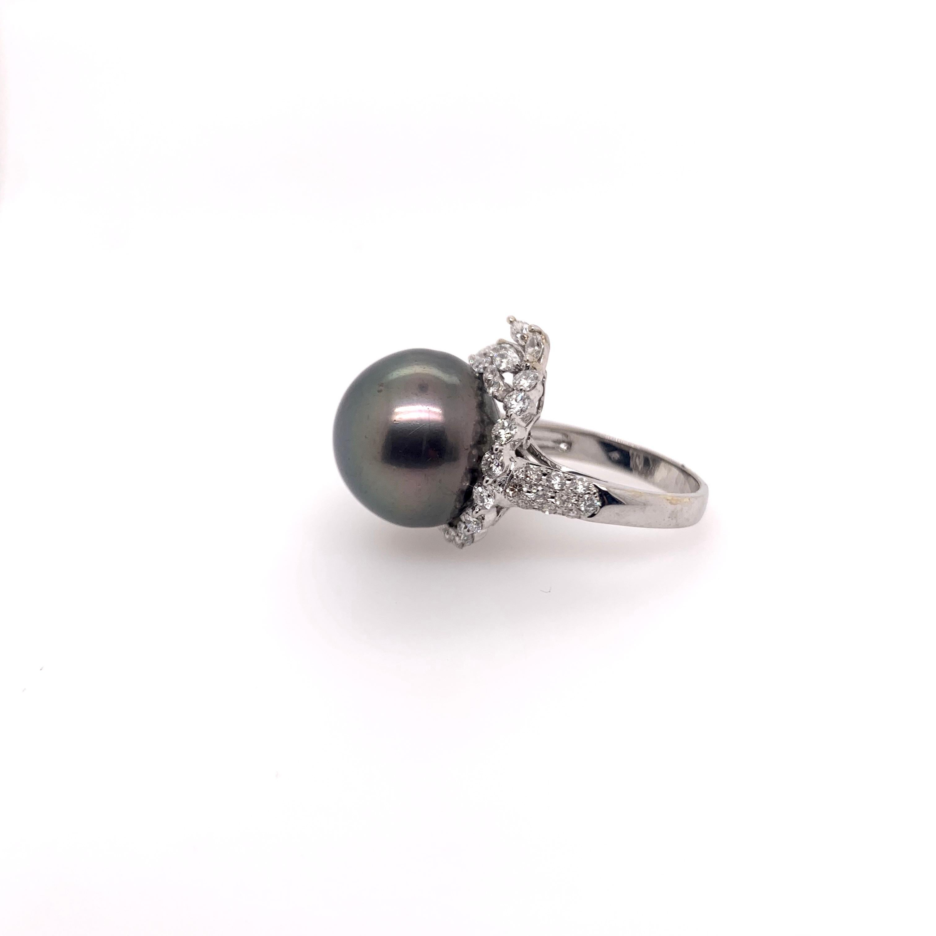Stunning 15mm black Tahitian pearl ring set in an asymmetrical diamond wrap around setting!   The pearl is generous in size with superb luster.   The round brilliant diamonds surround the pearl and has a slight flare on one end with marquis diamonds