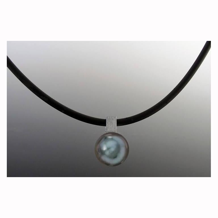 This White Gold Bail on Black Tahitian Pearl Pendant on Rubber Cord has a modern edge with the square bail which can hold different chains. It is shown here on a black rubber cord. Pearls are irregular and imperfect each one is unique. The pearls