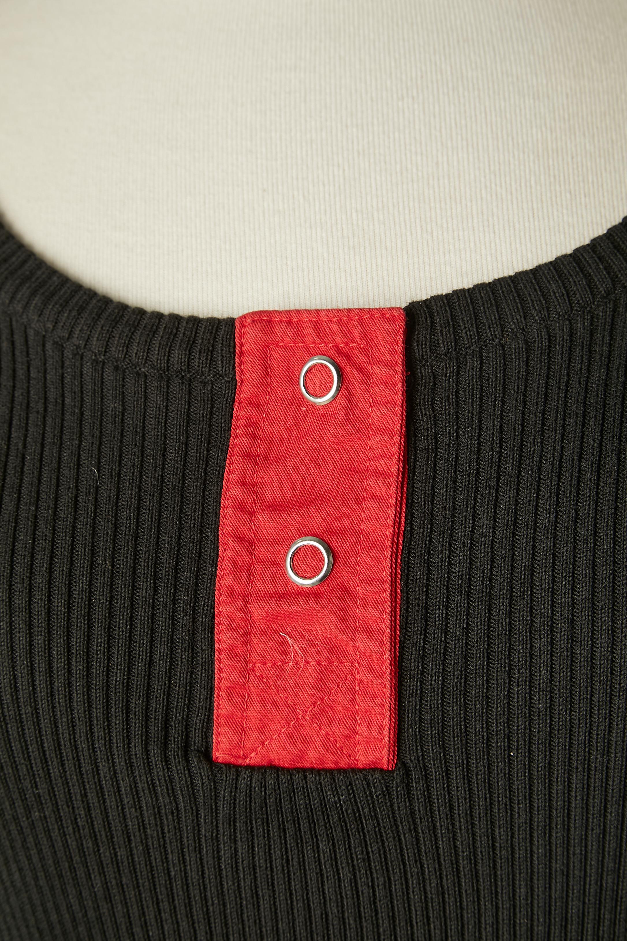 Tee-shirt noir avec manches rouges et orange. Encliqueter la partie supérieure au milieu de l'avant.
TAILLE 42 (It) 38 (Fr) 