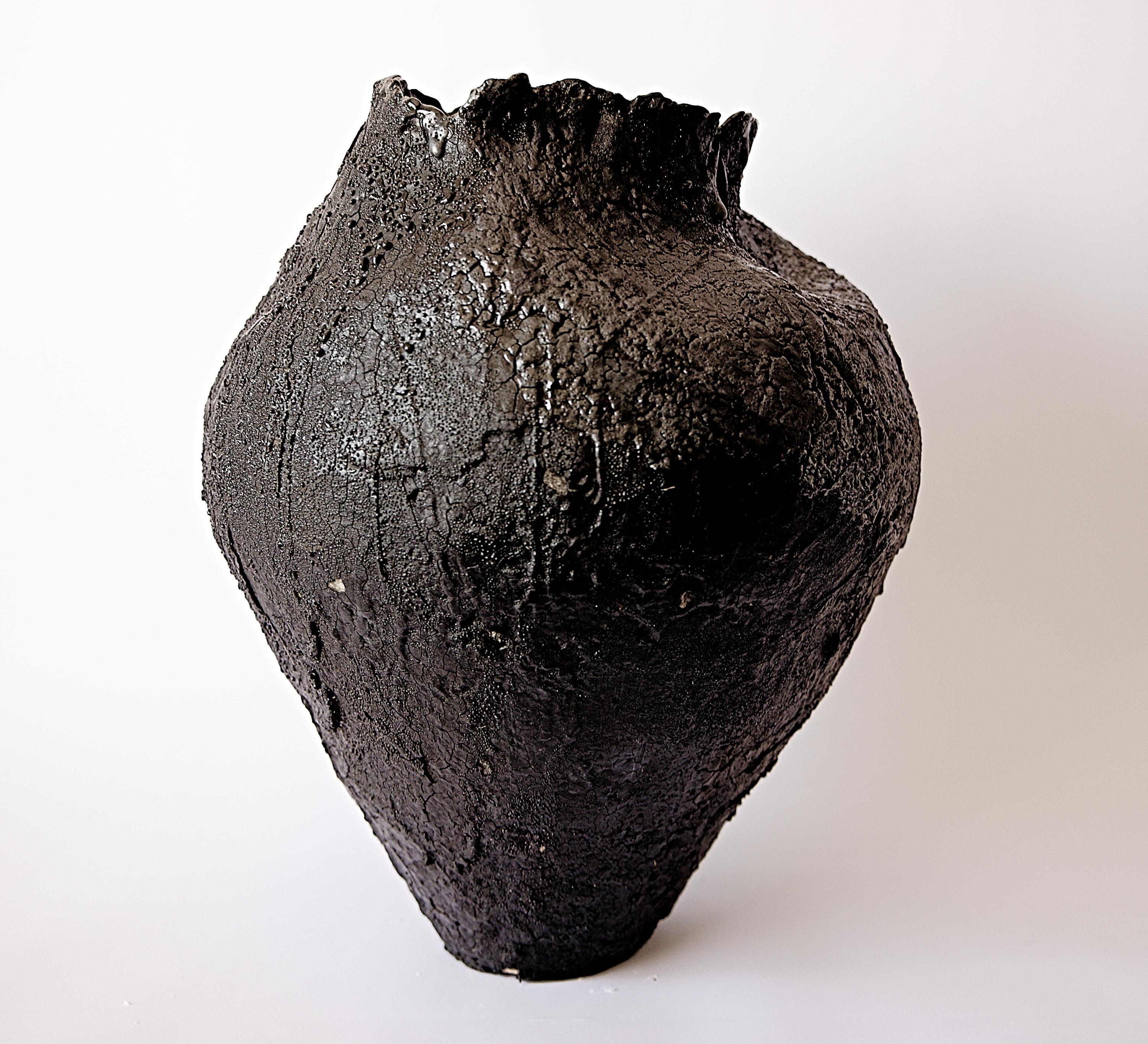 a mix of traditional with organic modern
large vessel is a true one of a kind Statement centerpiece 
 unique hand shaped vase with sculpted edges 
 
 full of levels of Black textures,mix of black gloss, testure and black matte surfaces
 
Torn edges,