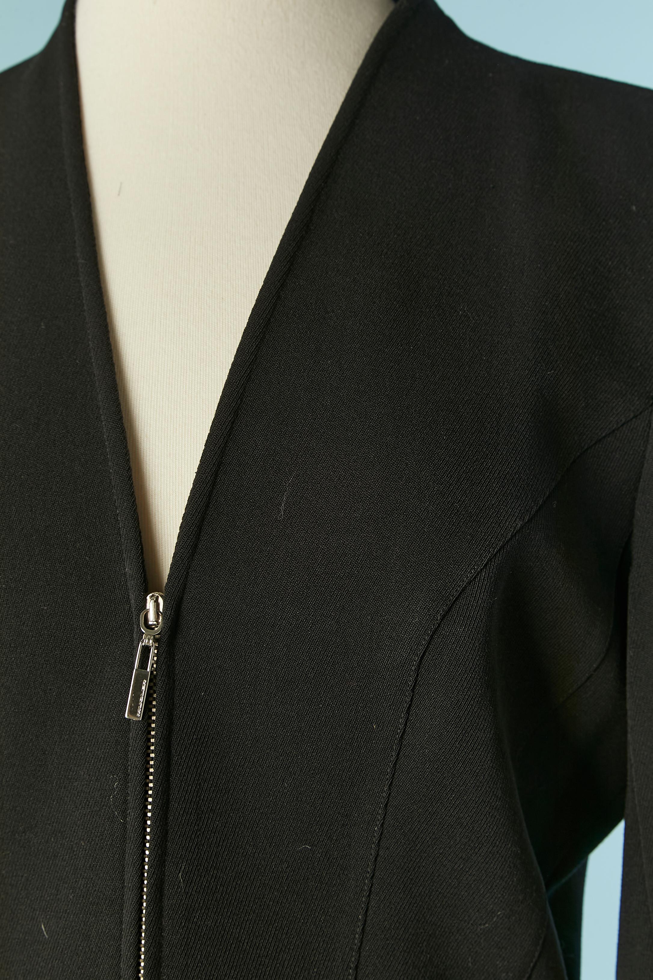 Gonna nera in lana sottile con chiusura a zip sul davanti e tirazip con marchio. 
Composizione del tessuto principale: 95% lana, 5% elastan. Fodera in acetato. 
Taglio e lavorazione. Tasca su entrambi i lati. 
TAGLIA 38 (Fr) M 
