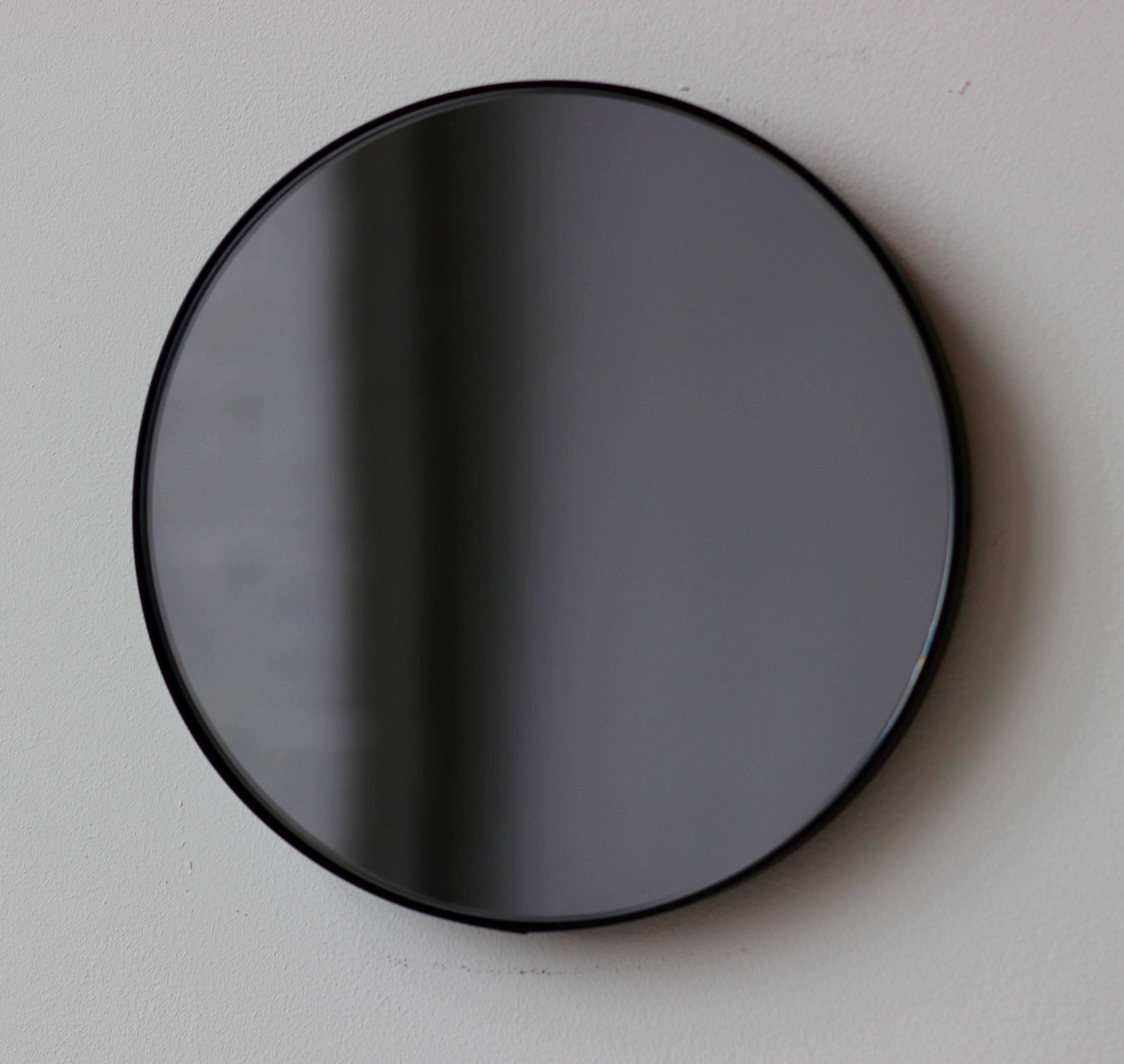 Contemporary Orbis™ round black tinted mirror with a minimalist aluminium powder coated black frame. Designed and handcrafted in London, UK.

Medium, large and extra-large mirrors (60, 80 and 100cm) are fitted with an ingenious French cleat (split
