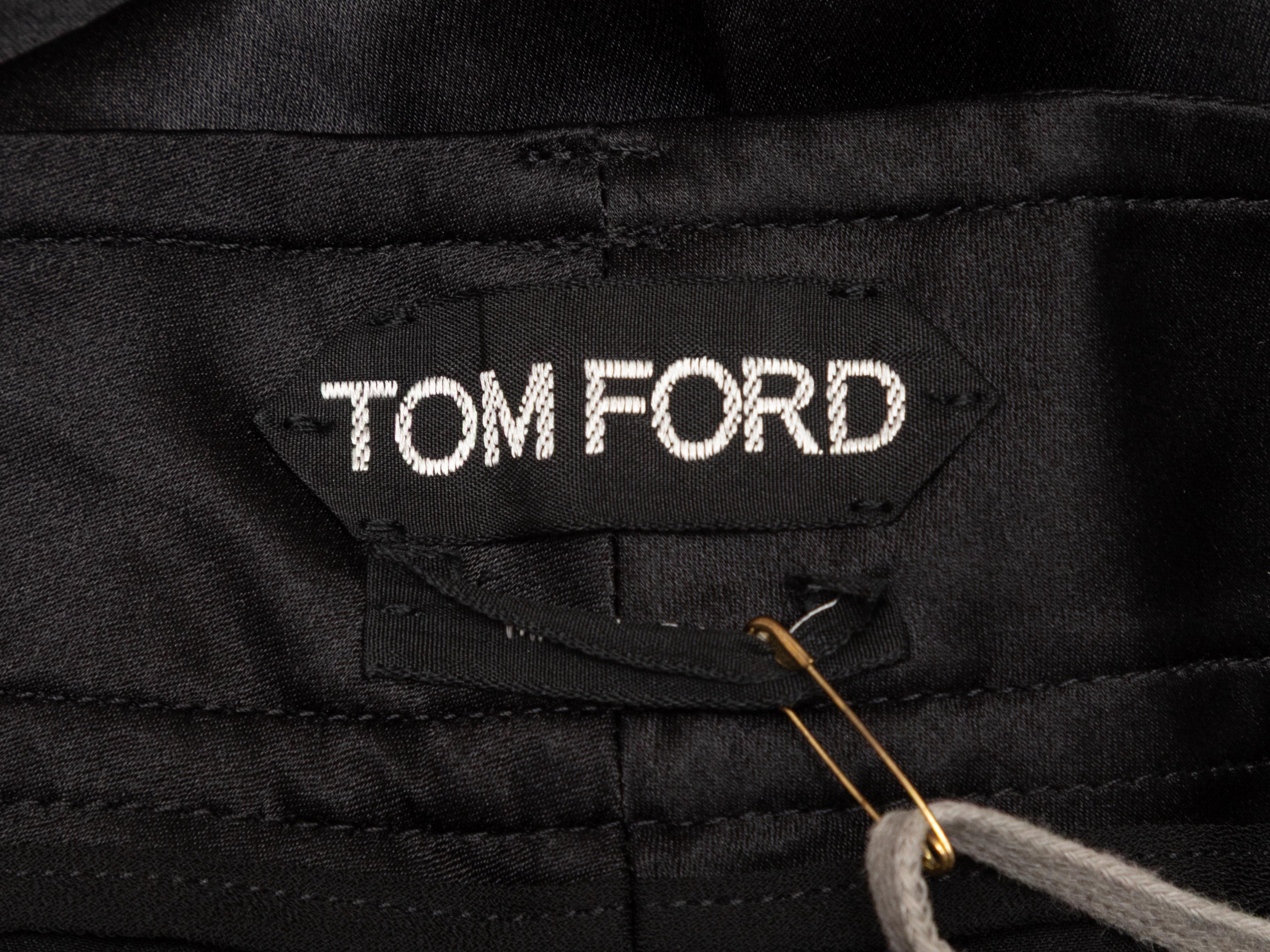 Pantaloni a gamba larga plissettati in seta nera di Tom Ford. Tasca a filetto sul retro. Chiusura frontale. Vita 36