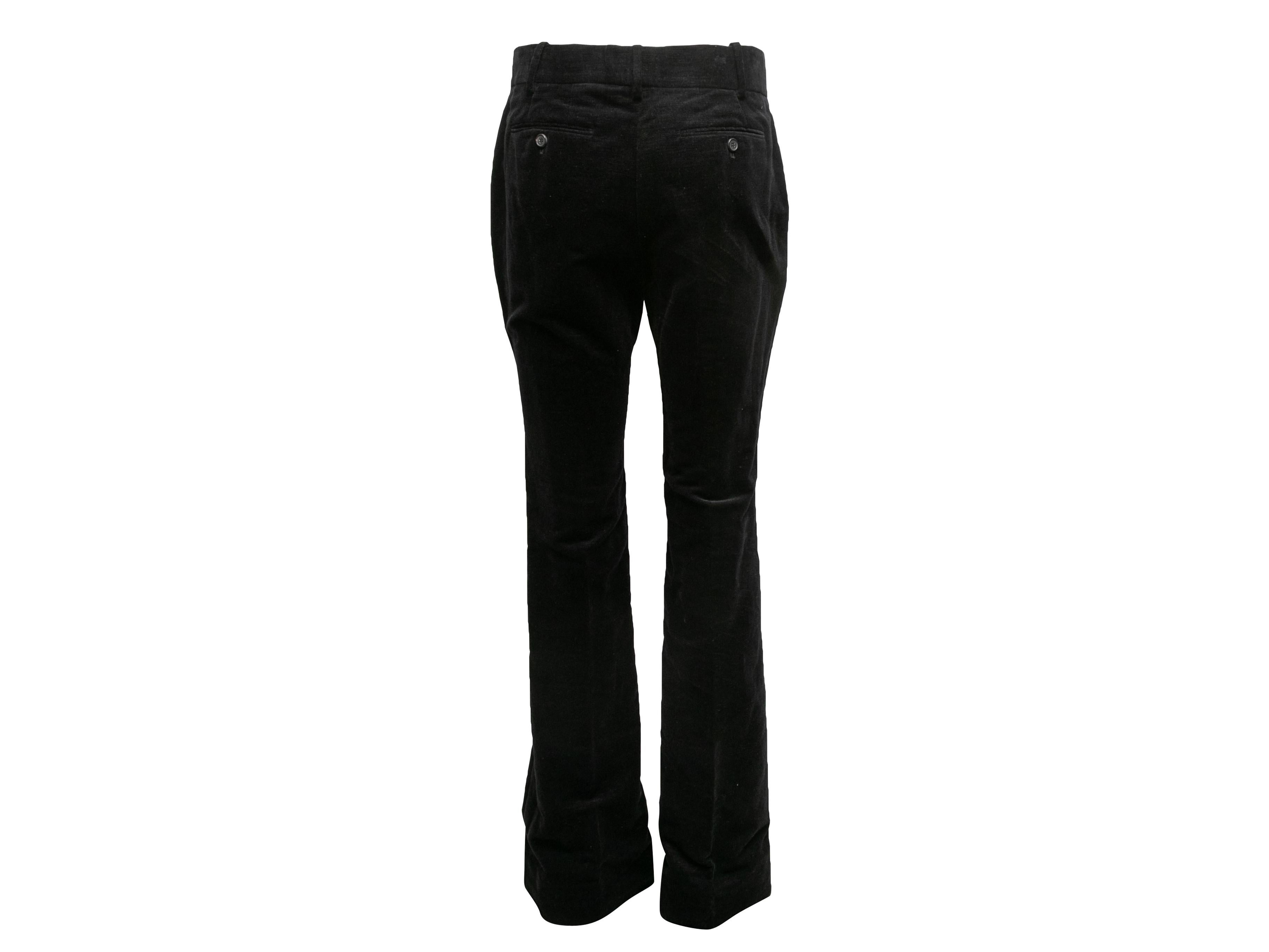 Black velvet bootcut pants by Tom Ford. Four pockets. Front closure. 30