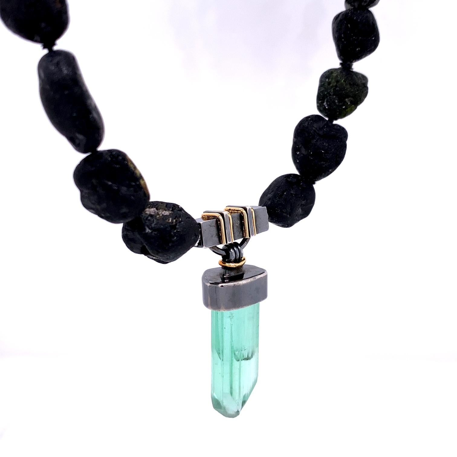 An oxidized sterling silver and 18k yellow gold clasp set with a green tourmaline crystal on a black tumbled tourmaline strand with stainless steel nittel parts. This necklace includes an 18k white gold web clasp to enable the black tourmaline to be