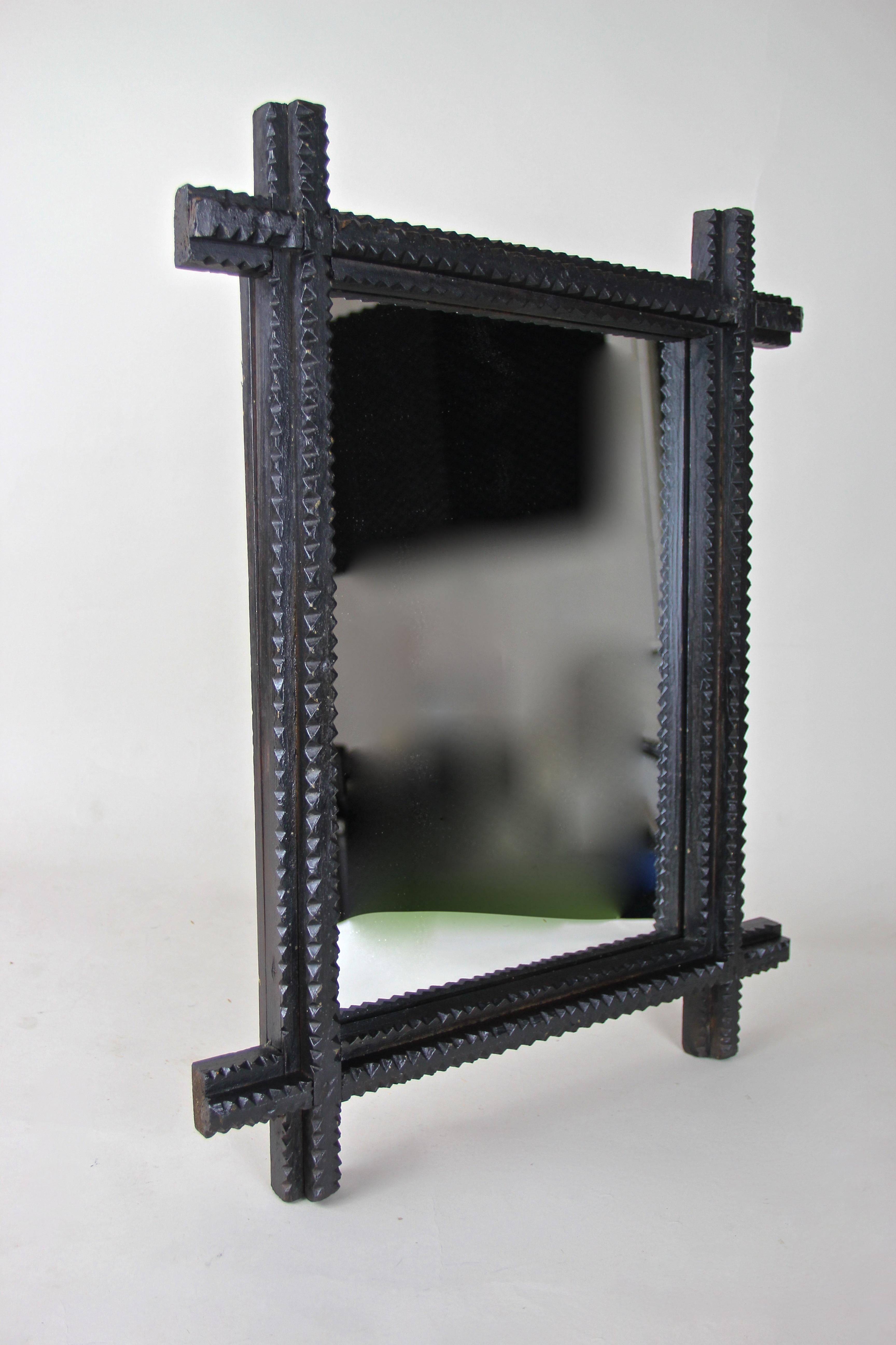 Beautiful black tramp Art wall mirror from the late 19th century. This Austrian wall mirror features a classic chip carving - a so called 