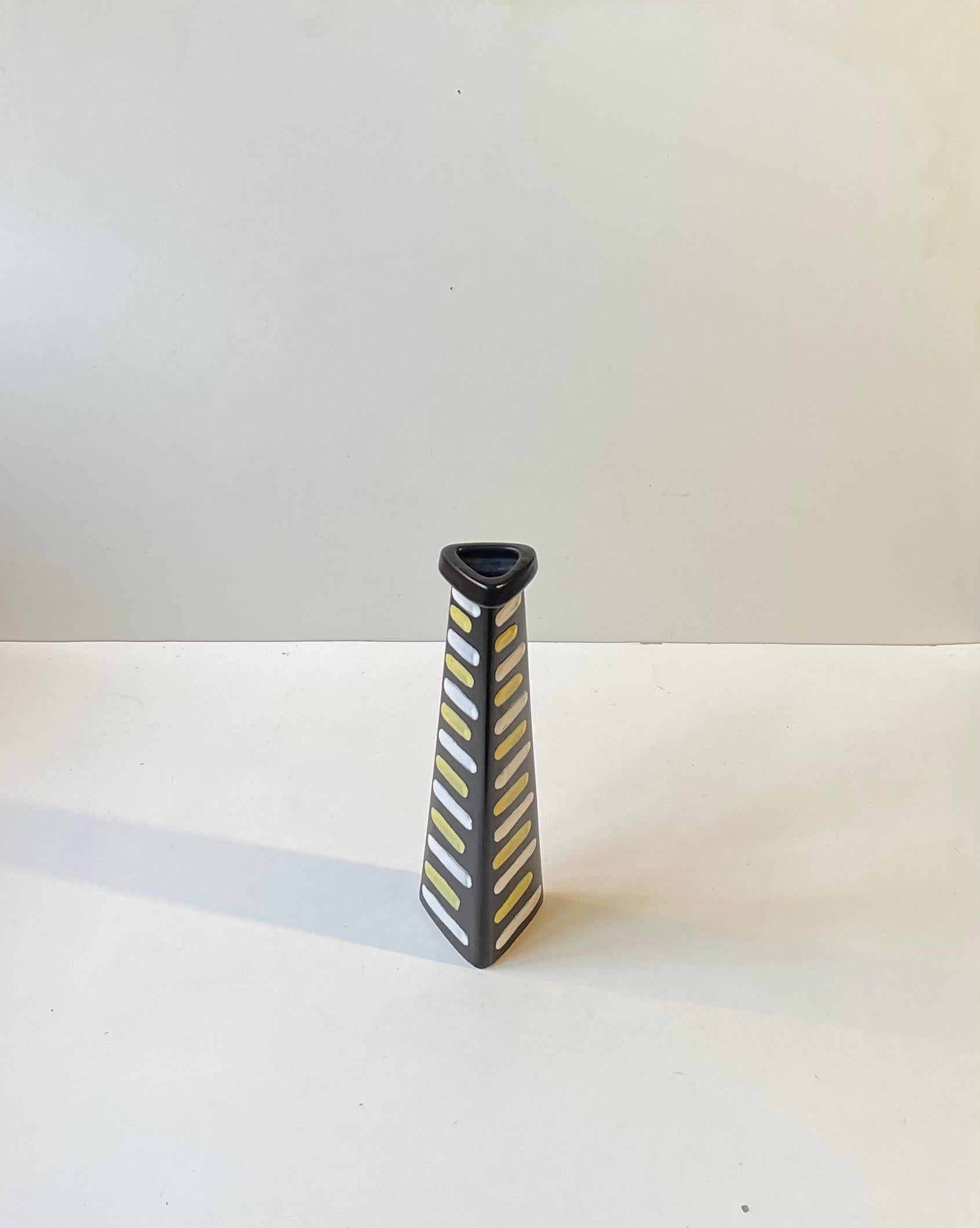 Eine seltene dreieckige Vase der Keramikerin Hjordis Oldfors. Es heißt Trio und zeigt naiv aufgetragene weiße und gelbe Linien auf einer schieferschwarzen Hauptglasur. Hergestellt Ca. 1954 in Upsala Ekeby in Schweden. Vollständig