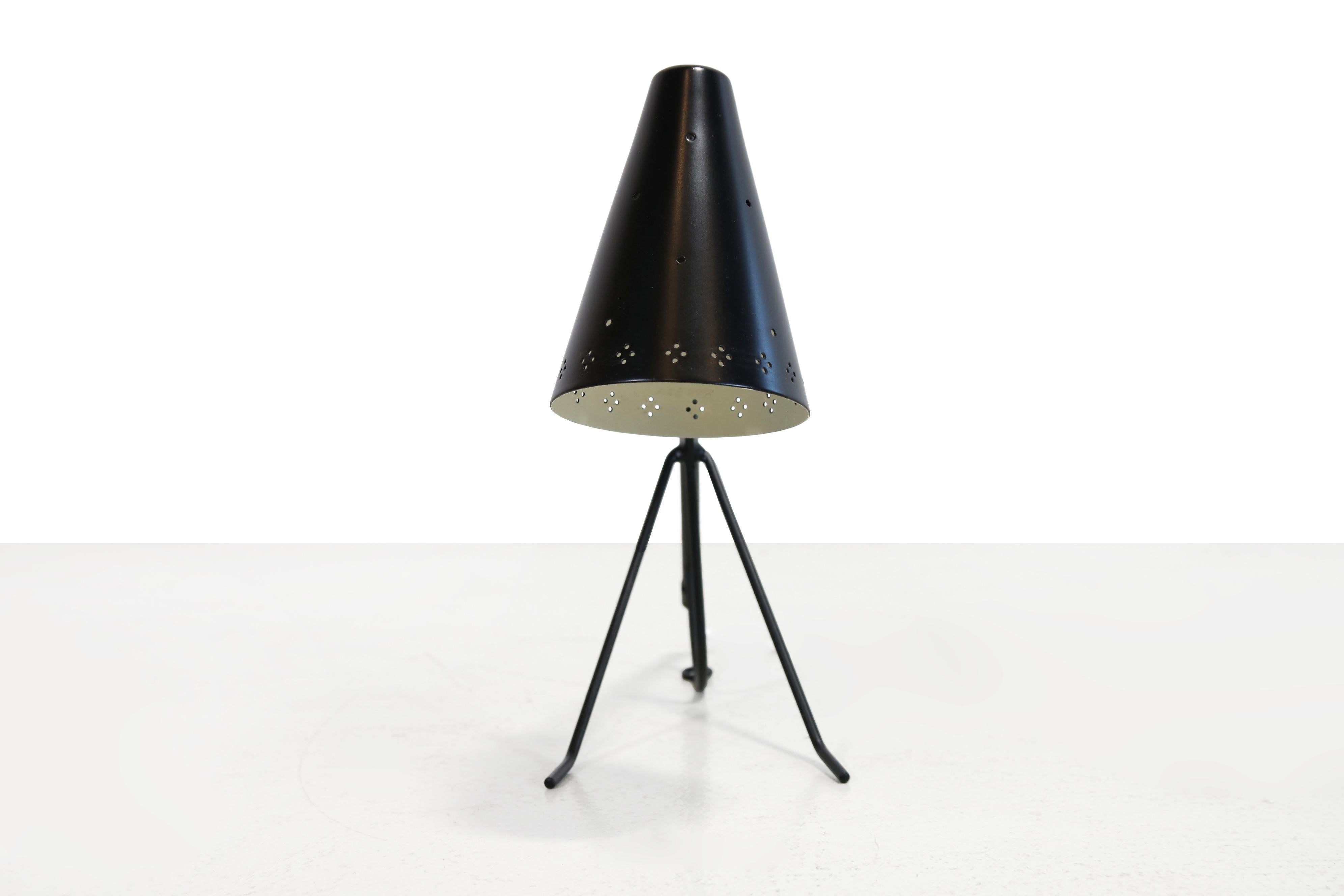 Minimalist table lamp from Falkenbergs Belysning, Sweden, dating from the 1950s. The lamp features an elegant conical shade with perforations around the edge, creating a pleasant lighting effect. It has an E14 socket. The sleek black metal frame