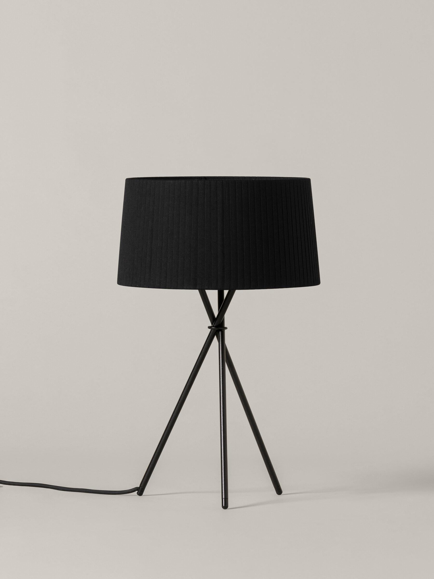 Black Trípode M3 table lamp by Santa & Cole
Dimensions: D 31 x H 50 cm
Materials: Metal, ribbon.
Available in other colors.

Trípode humanises neutral spaces with its colourful and functional sobriety. The shade is hand ribboned and its base