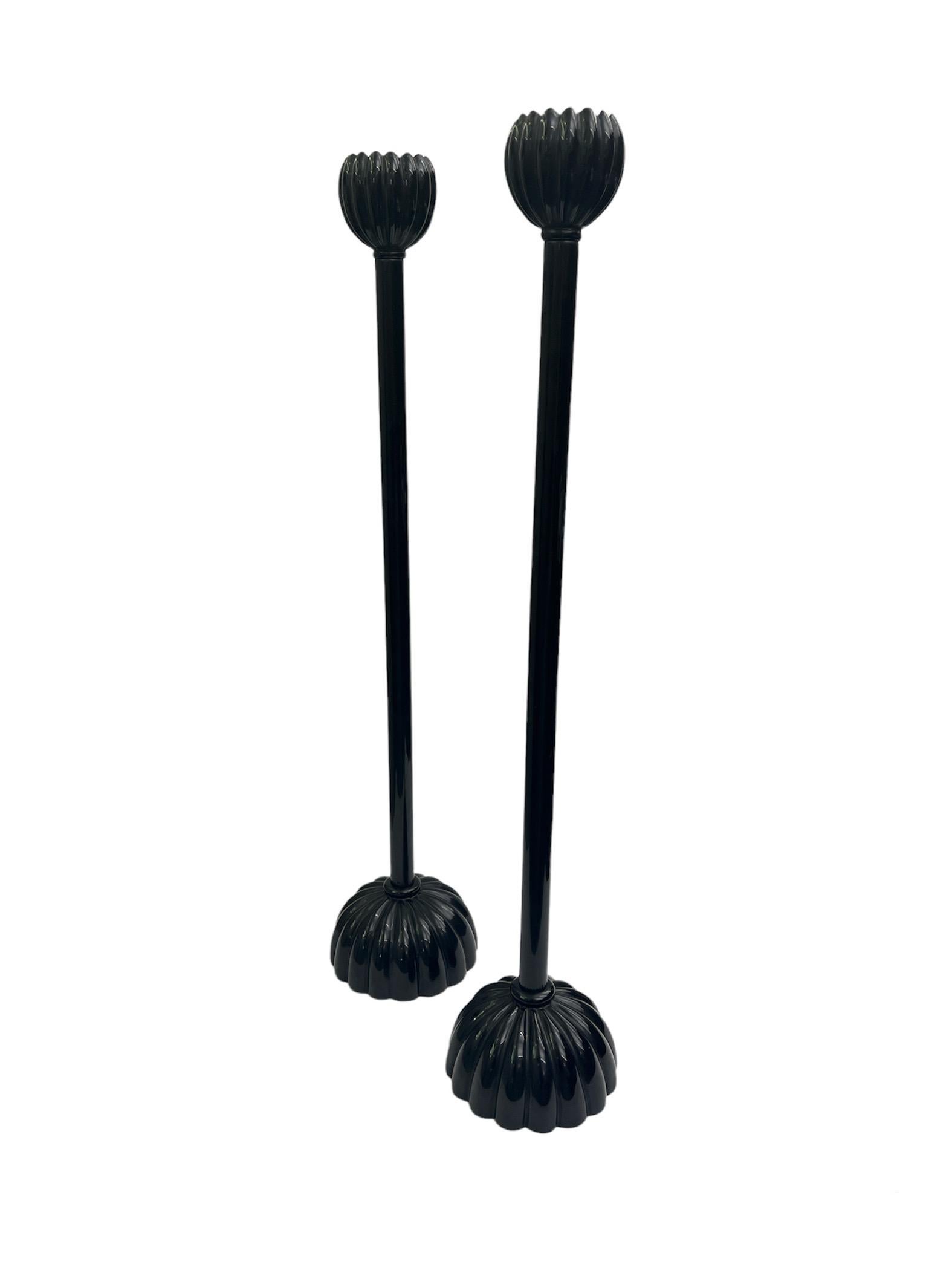 A pair of tall and elegant Japanese style black lacquered candlesticks from the late 20th Century . Out of the reeded base forms a long stem with a tulip form top to place candles.

Property from esteemed interior designer Juan Montoya. Juan Montoya