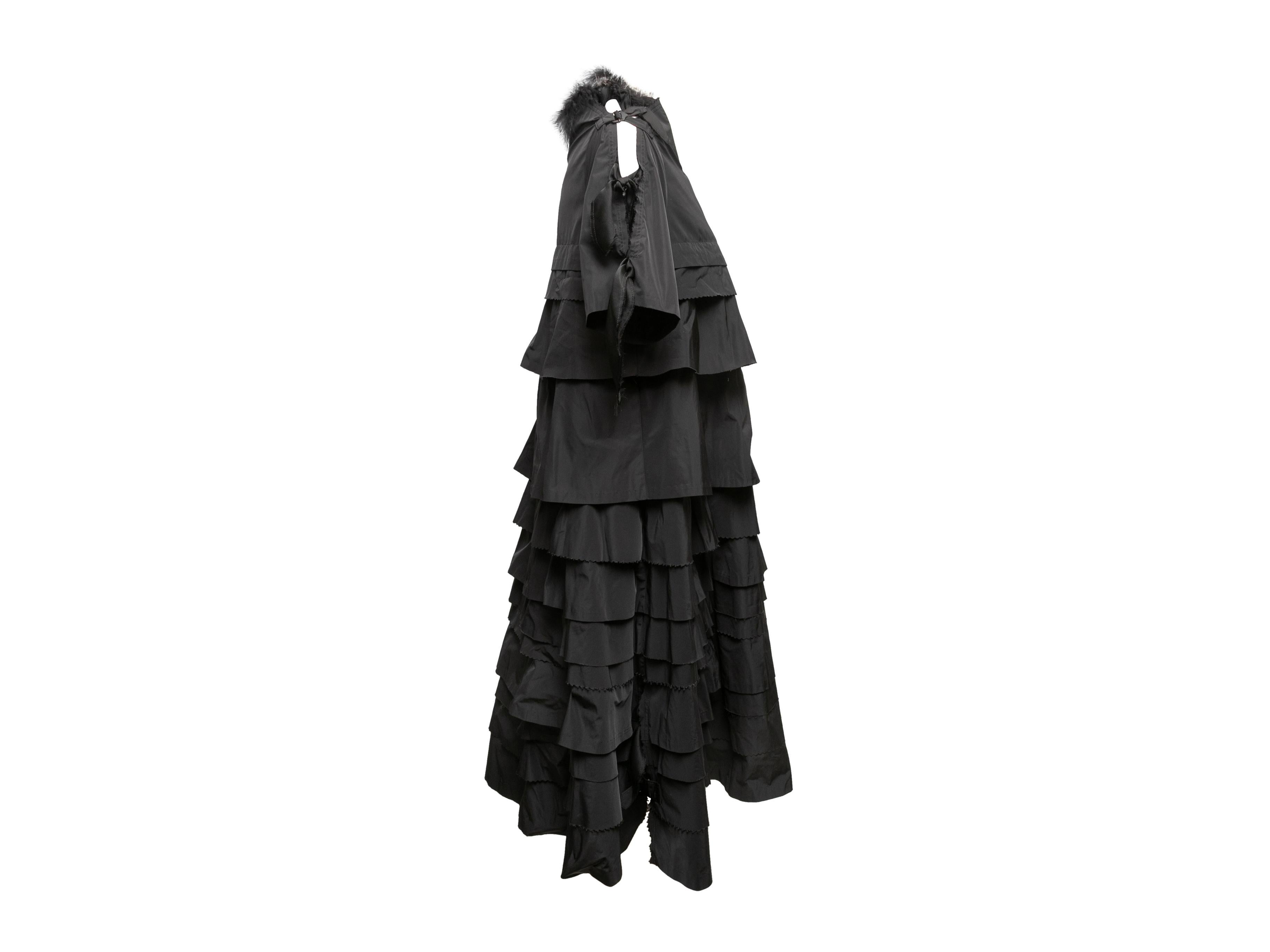 Black tiered dress by Undercover Jun Takahashi. Feather trim at shoulders. Crew neck. Short sleeves. Zip closure at center back. 33