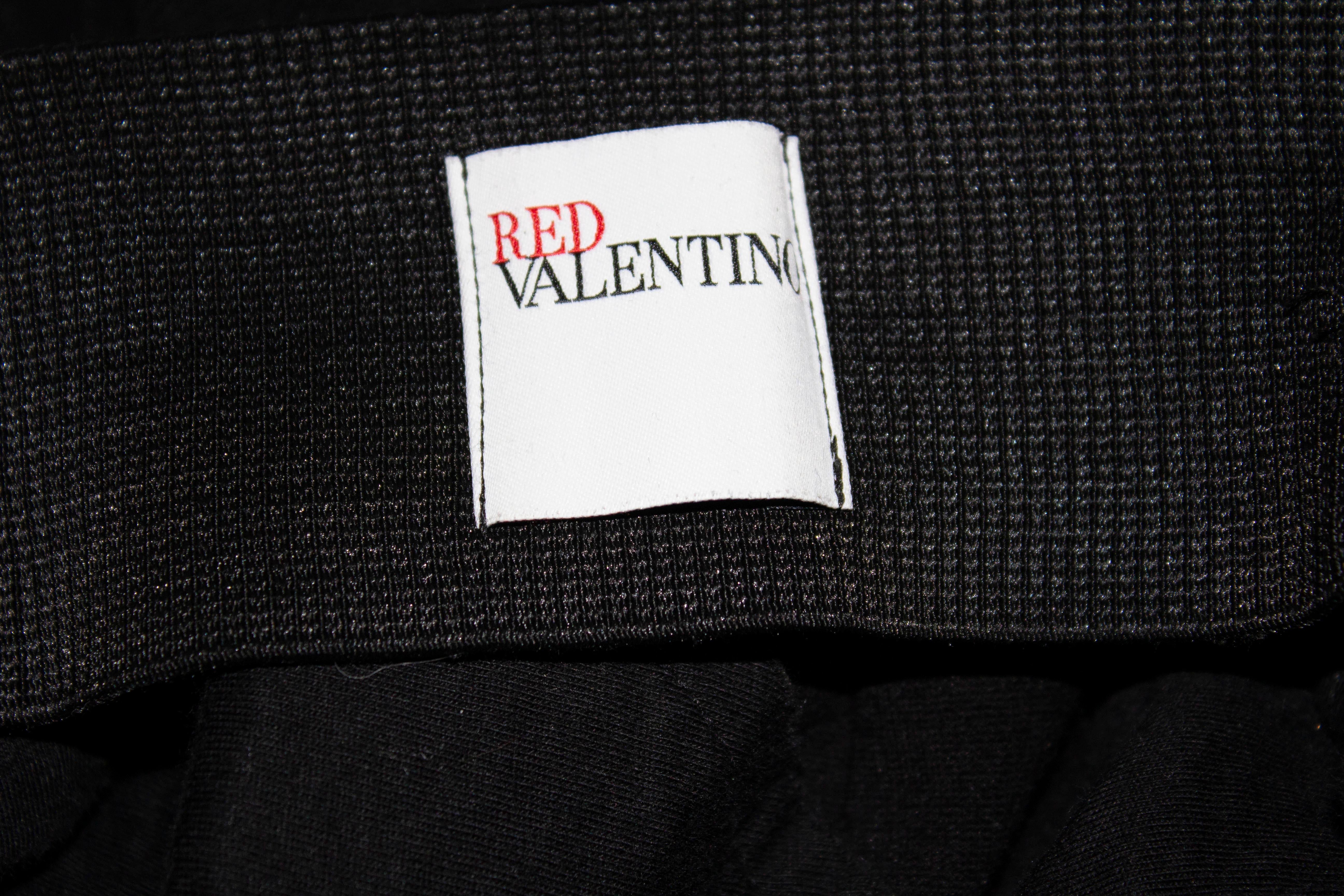 A chic cocktail dress by Valentino , Red line. The dress has an off the shoulder petal detail and slips over the head. Measurements : bust 34'' ,length 37''