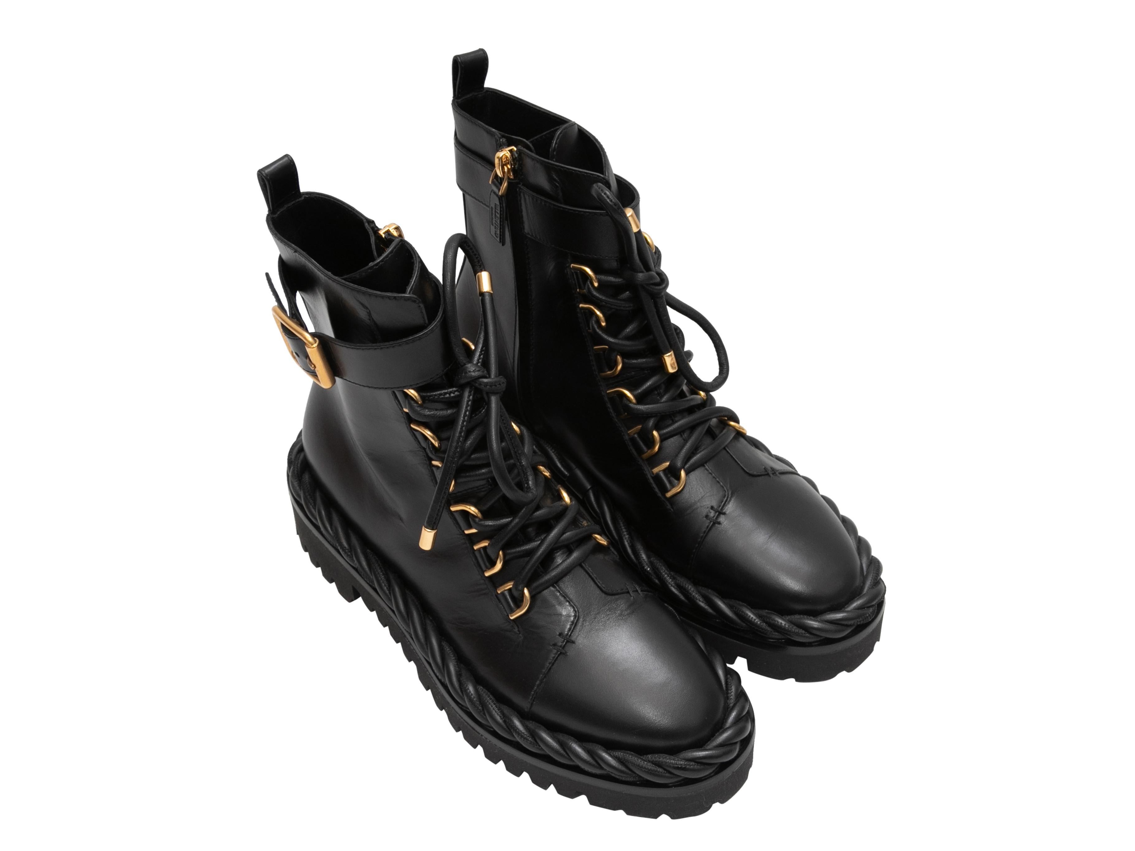 Black leather combat boots by Valentino. Gold-tone hardware. Twisted trim at lug soles. Lace-up and buckle detailing at tops. Zip closures at inner sides. 6
