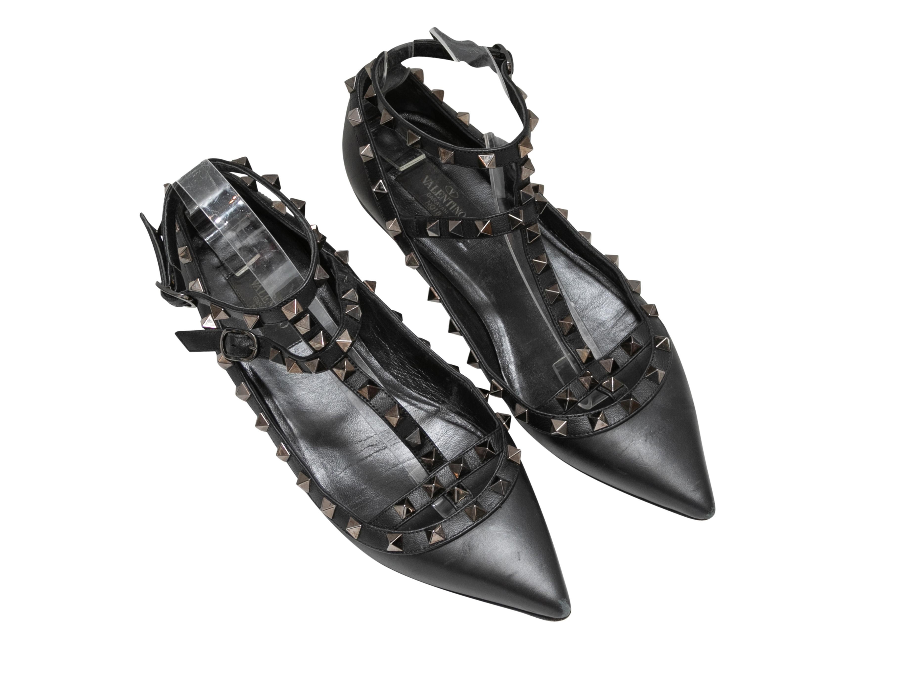 Black leather pointed-toe gladiator ballet flats by Valentino. Gunmetal Rockstud trim throughout. Buckle closures at ankle straps. 2.5