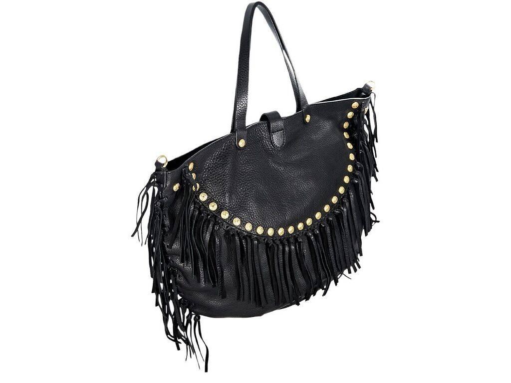 Product details:  Black pebbled leather Rockabee tote bag by Valentino.  Accented with fringe and studs.  Dual shoulder straps.  Detachable studded shoulder strap.  Top snap strap over zip closure.  Lined interior with inner zip and slide pockets. 