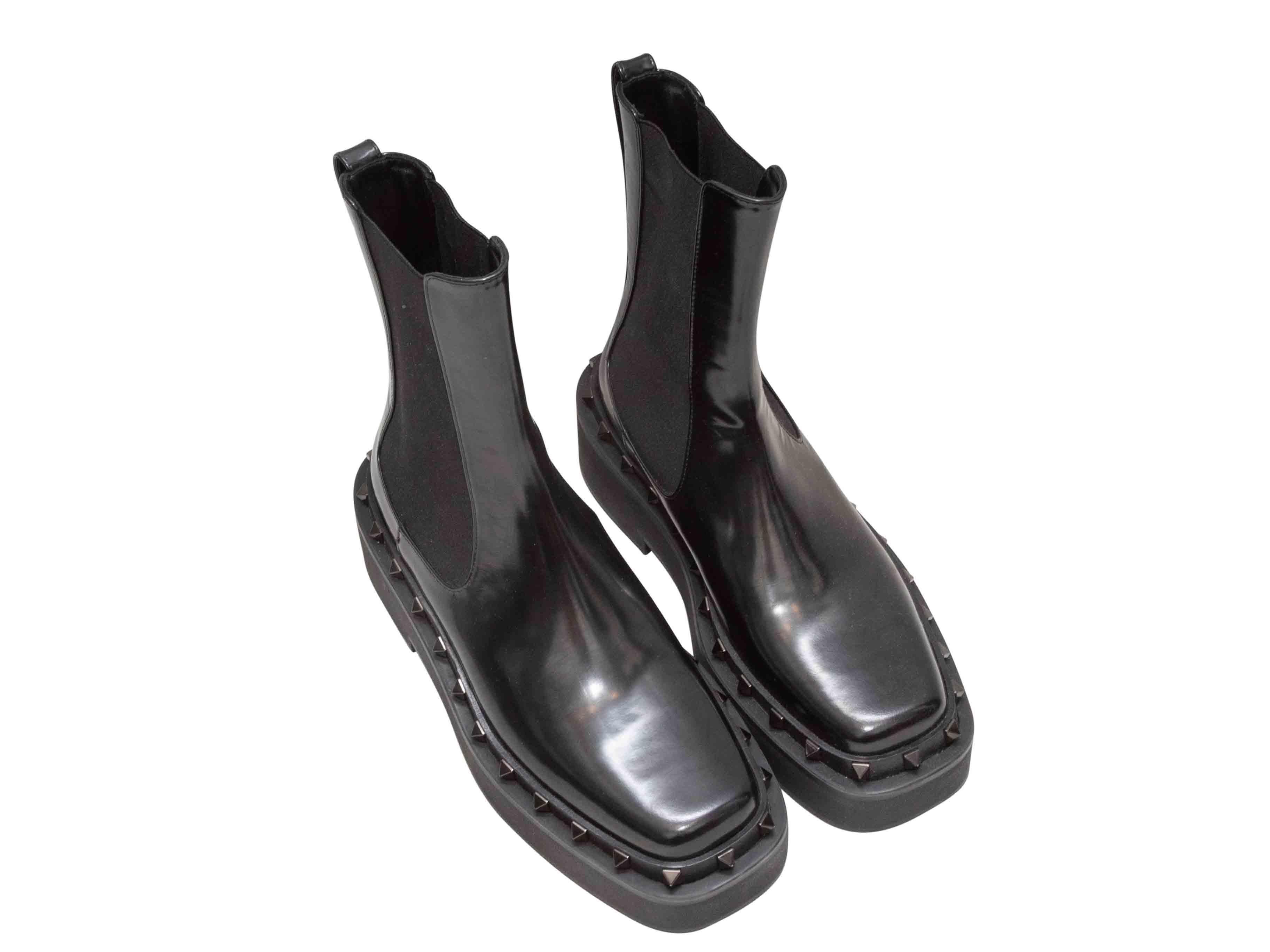 Black leather platform ankle boots by Valentino. Rockstud trim at soles. Elasticized gores at sides. 7