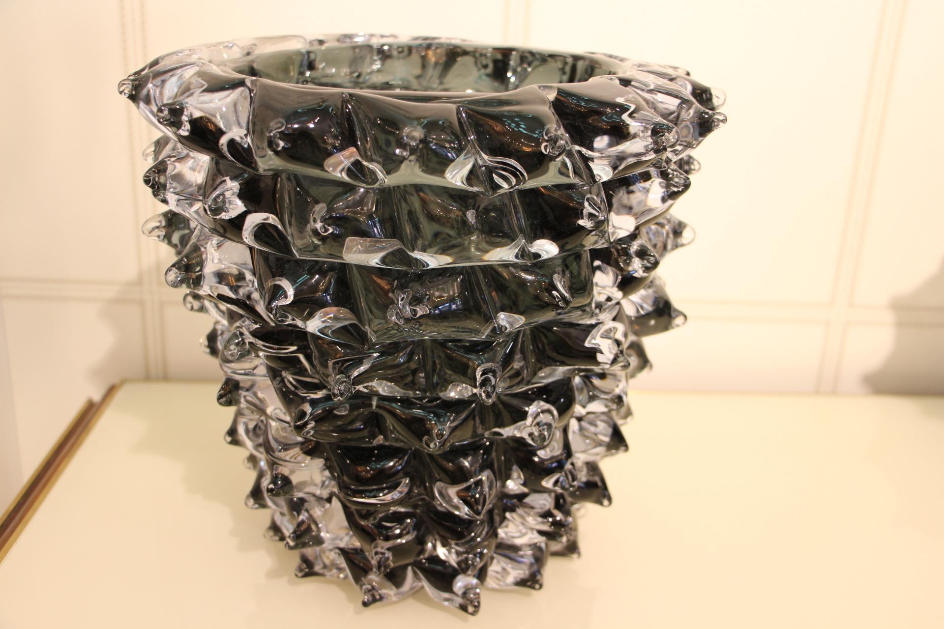 A spectacular piece of Venetian vases, imposing size in clear and deep dark blown Murano glass, hand decorated with the rostrato technique: spikes of glass individually pulled in relief.
Thick walled casing glass produces a lot of iridescent