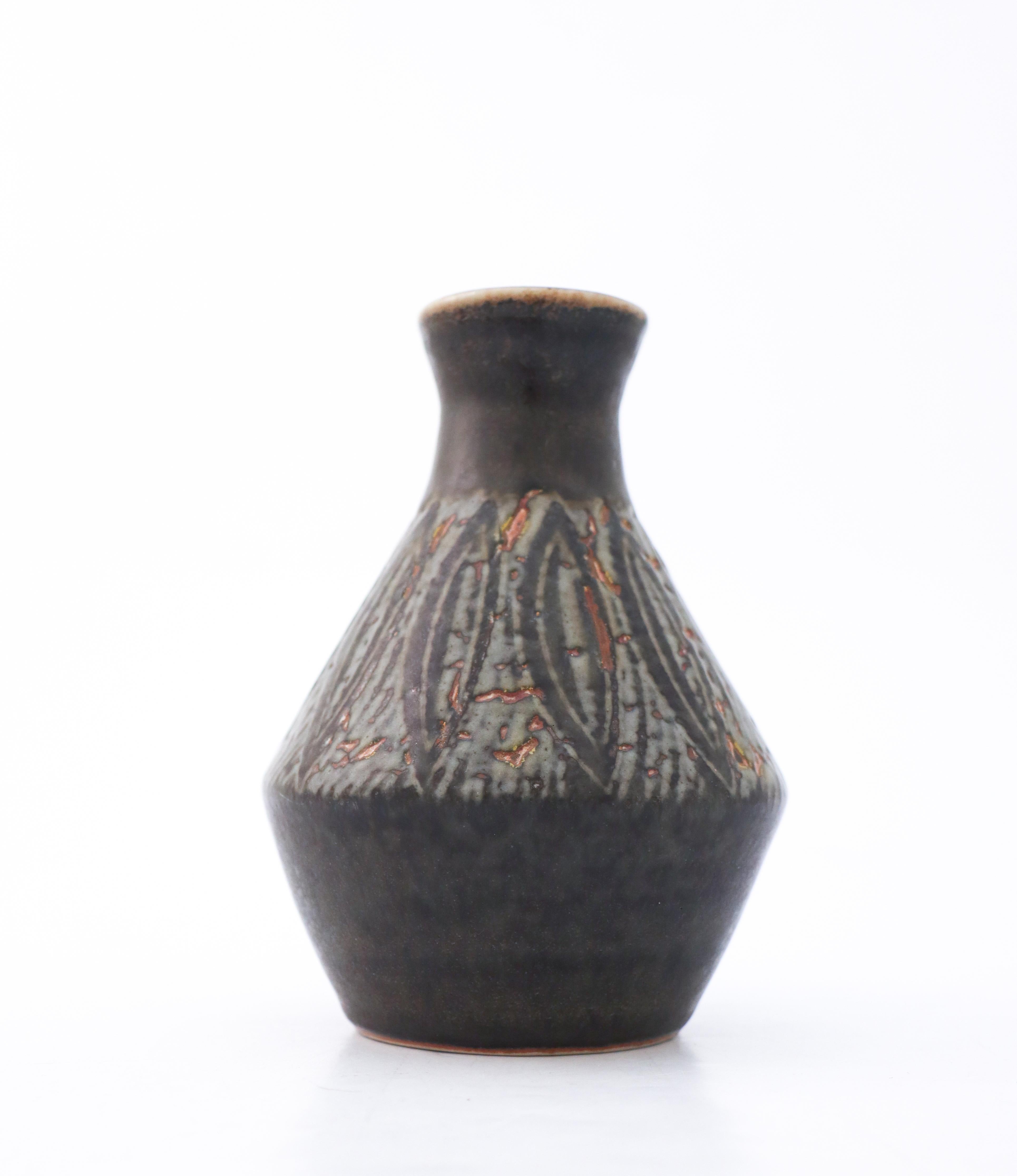 A black vase with some minor brown color at the bottom designed by Carl-Harry Stålhane at Rörstrand, It is 21 cm (8.4