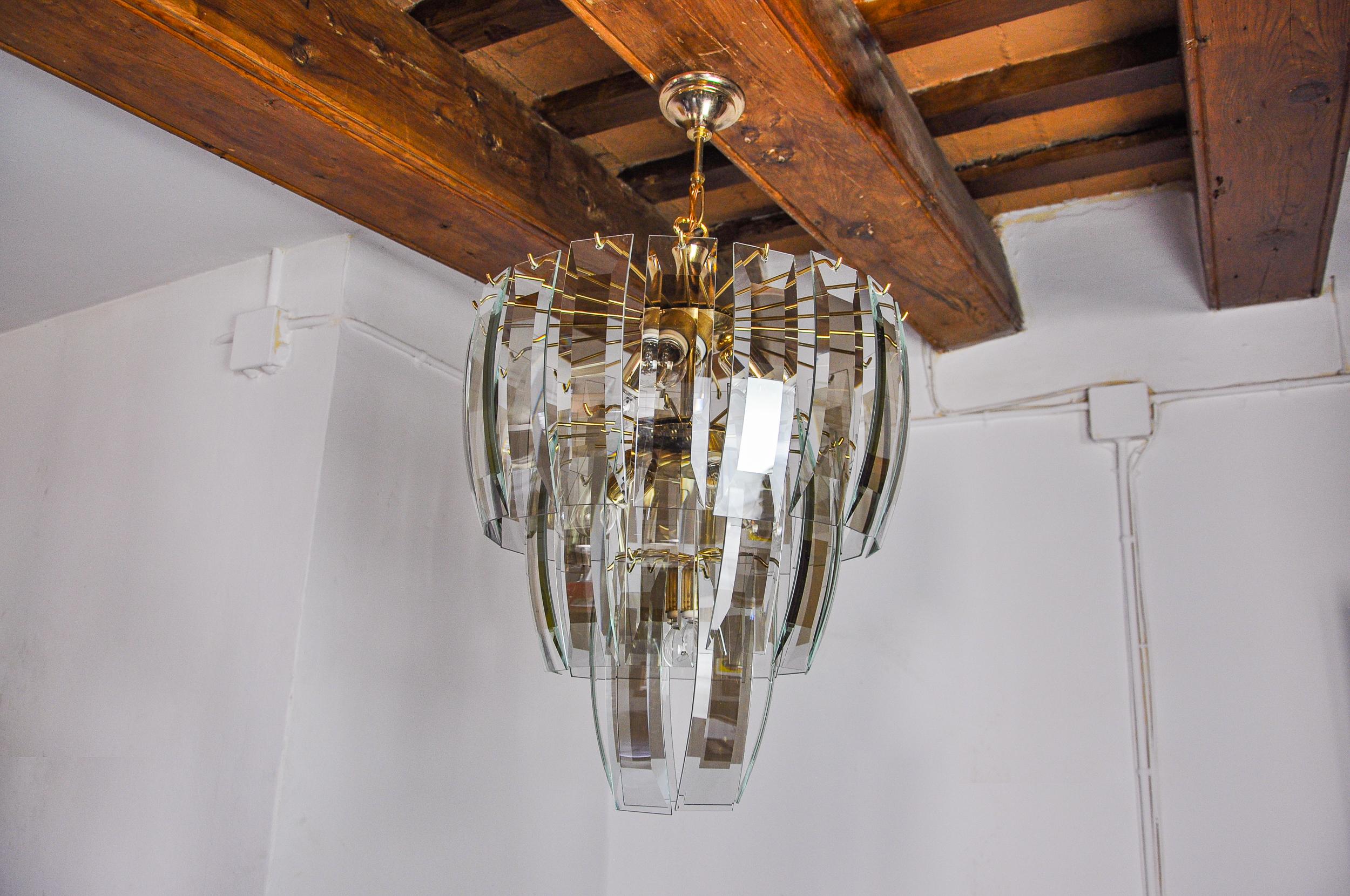 Superb Veca chandelier designed and produced in the 70s in Italy. Golden structure and black beveled crystals spread over 3 levels. Very beautiful decorative object that will illuminate your interior wonderfully. Electricity checked, marks of time