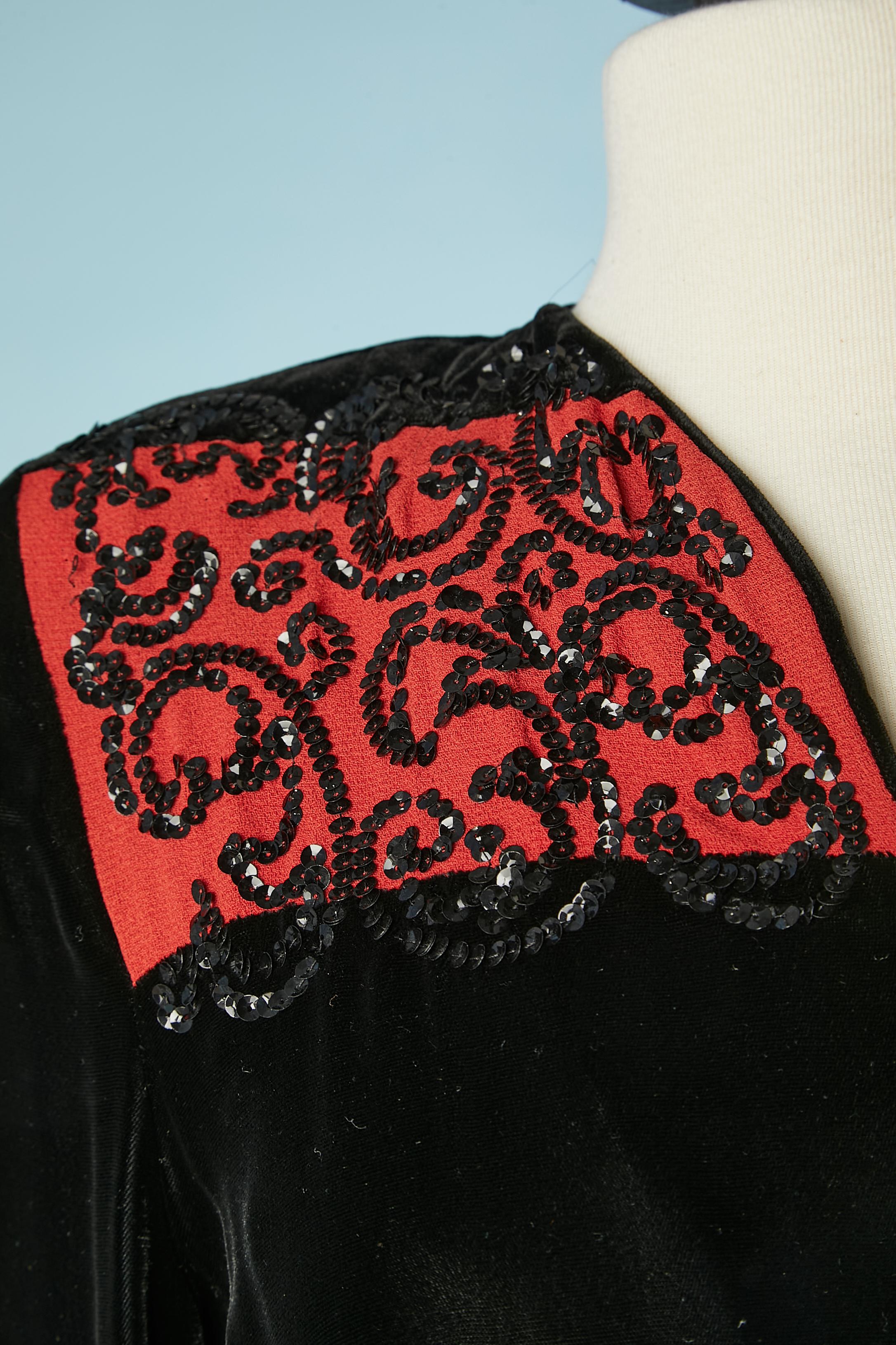 Robe du soir en velours noir et crêpe rouge, ornée de paillettes. Ceinture en velours avec bouton et boutonnière + passant de ceinture. Fente sur le milieu du front. 
TAILLE 36 (Fr) S 