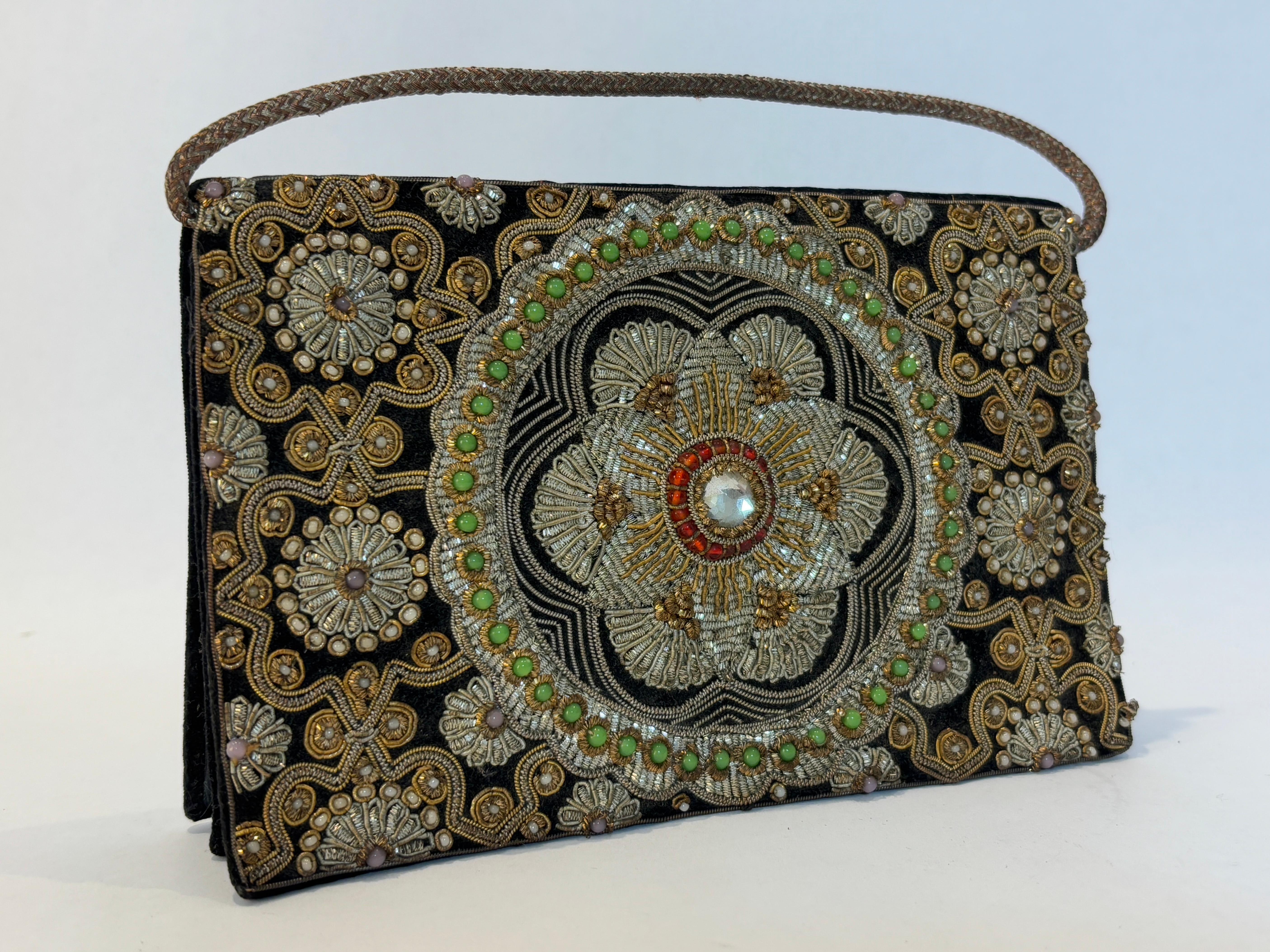 Vintage 1960s Zardozi Zari gemstone clutch.
Beautiful 1960s Zardozi Zari gem-set black velvet and silk embroidered with beads evening jeweled luxury purse.
The silk velvet rectangular bag, embroidered with a quatrefoil lattice design in gold and