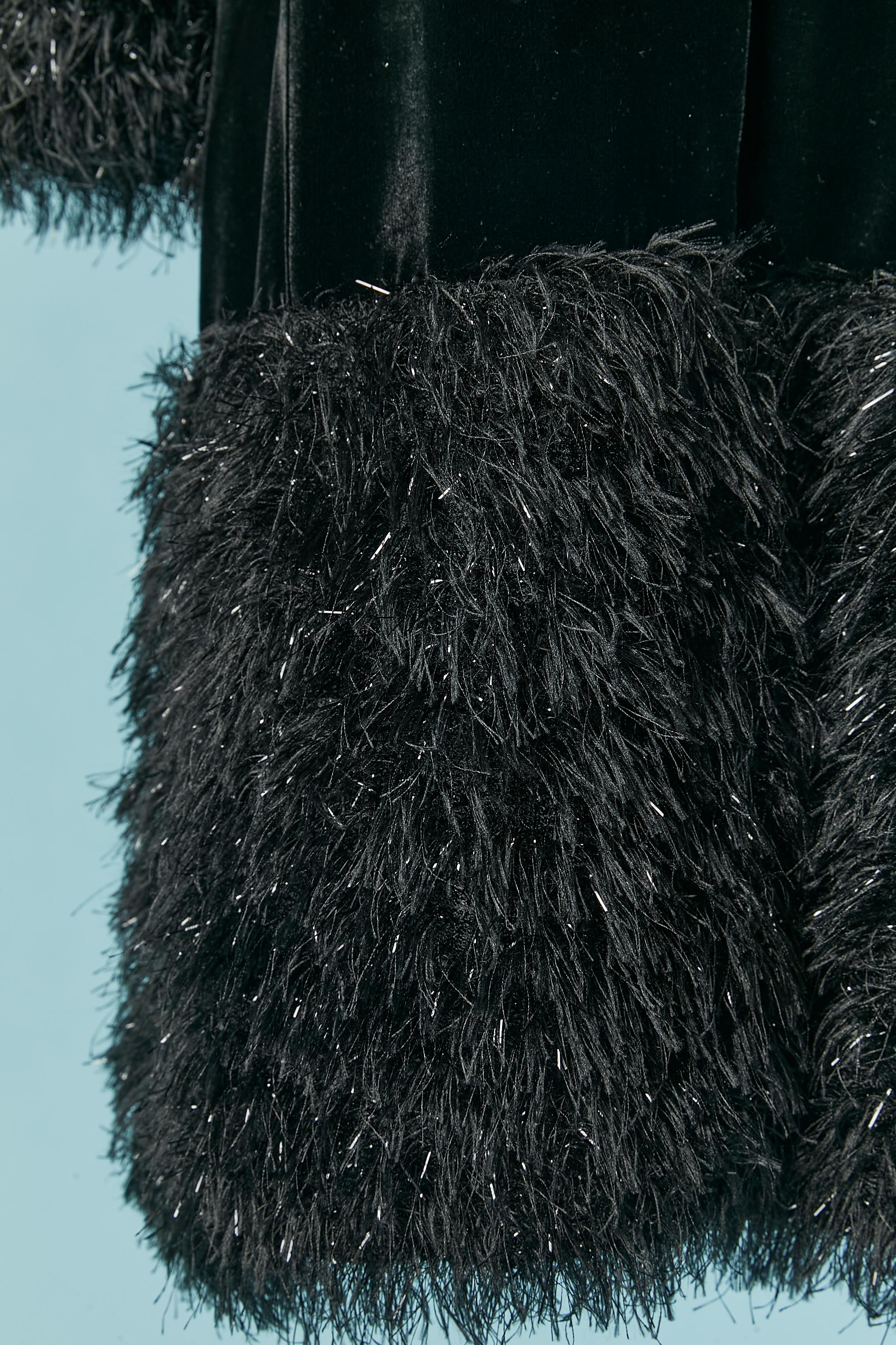 Cappotto in velluto nero con bordo in fili neri e lurex. Composizione del tessuto principale: 33% seta, 67% acetato. Non ci sono indicazioni sulla composizione della fodera, ma probabilmente si tratta di rayon 
Chiusura a scatto (ricoperta di