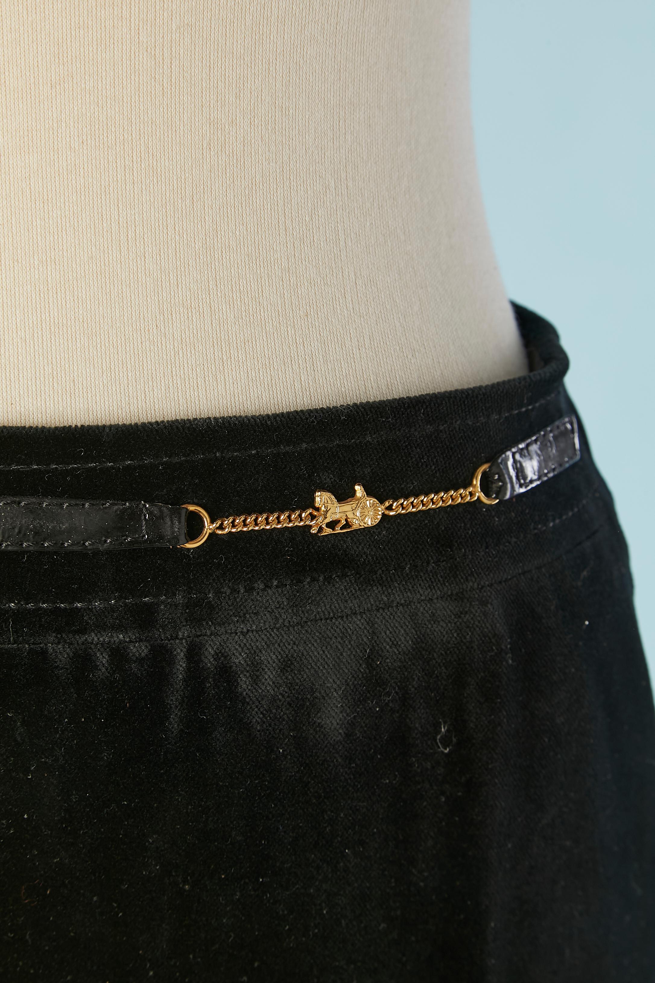 Langer Bleistiftrock aus schwarzem Samt mit Markenzeichen in der Taille und glänzenden Lacklederdetails.  Innenfutter aus Viskose mit Markenzeichen. Reißverschluss und Haken-Ösen-Verschluss in der oberen Rückenmitte. Auf der Mitte des Rückens