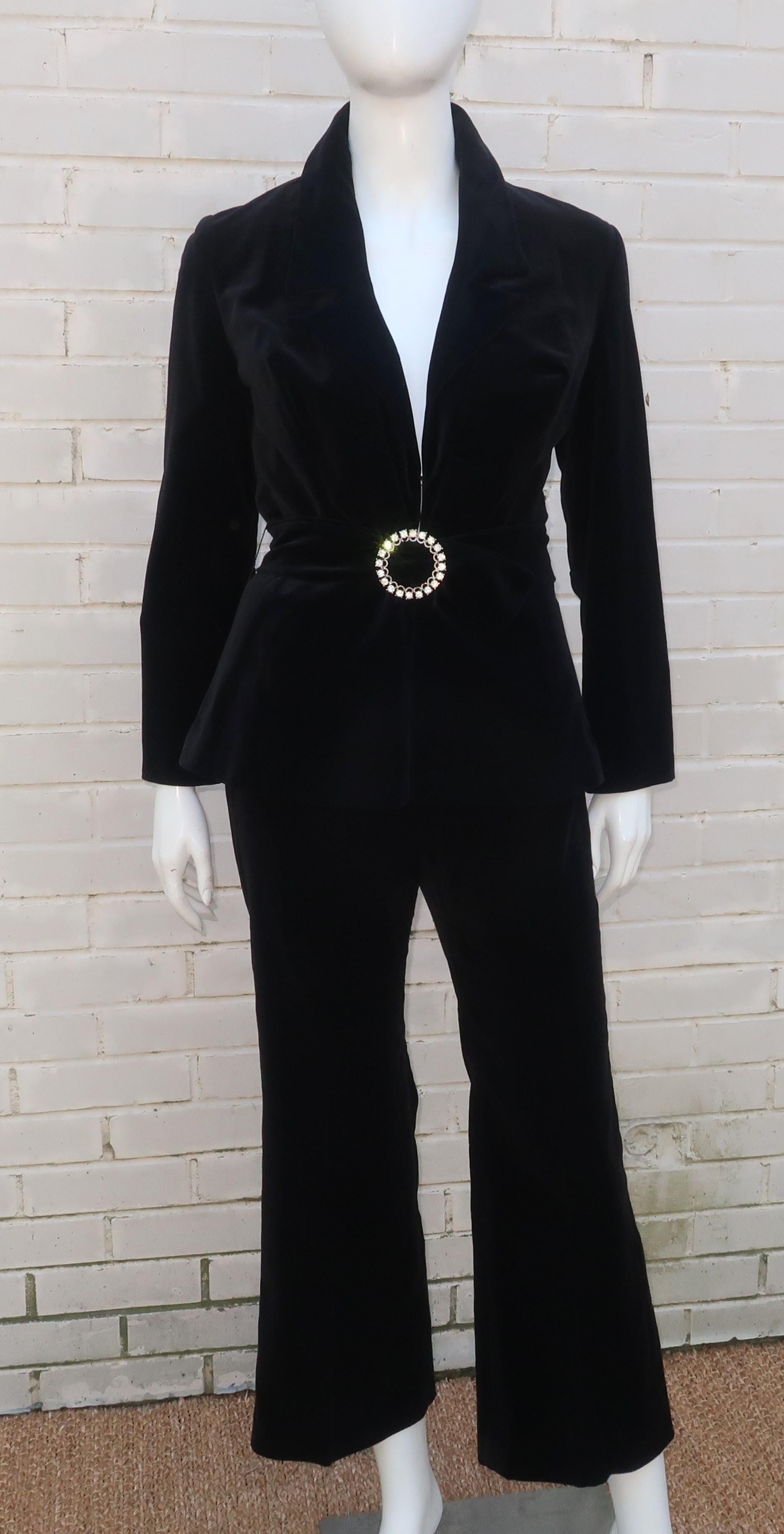 Fab C.1970 black velvet pant suit by Y.E.S. of California.  The jacket hooks at the front with a peplum silhouette and features a coordinating belt with rhinestone buckle.  The pants sit high on the waist and zip at the back with a slight bell