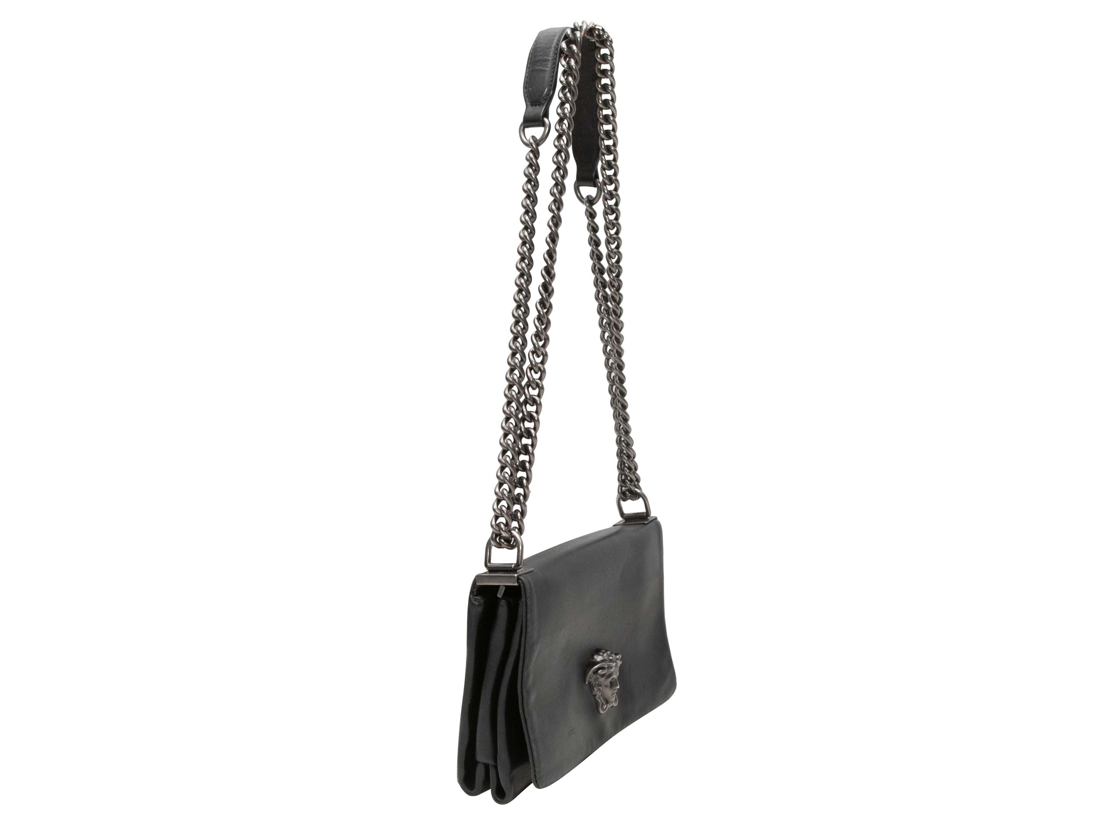 Black Versace Palazzo Medusa Head Shoulder Bag. The Palazzo Shoulder Bag features a leather body, gunmetal hardware, front Medusa head adornment, dual chain-link shoulder straps, and a front flap closure. 8.5