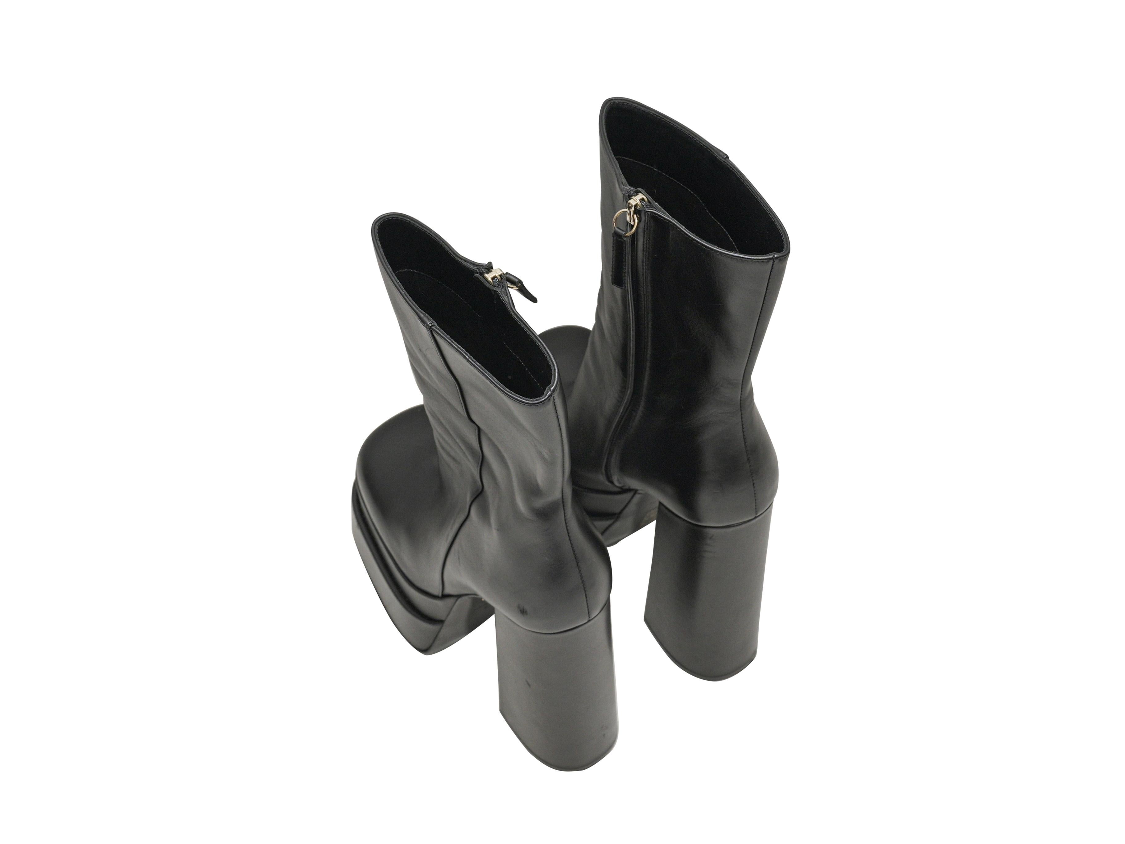 Black leather platform square-toe ankle boots by Versace. Zip closures at inner sides. 7