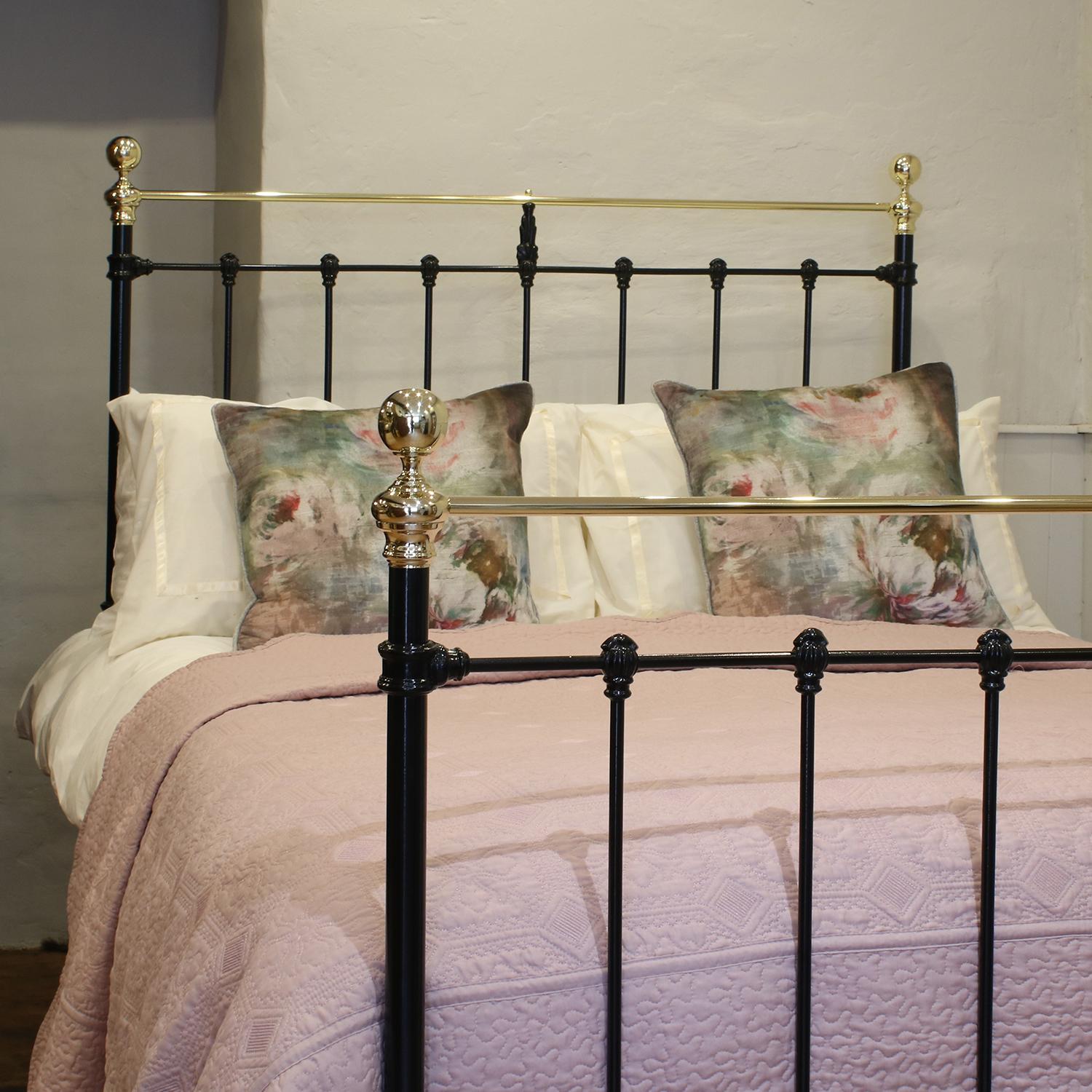 Victorian brass and cast iron bedstead, finished in black with a curved top brass rail. The head and foot board have attractive mouldings alongside a central brass finial in the foot board and a cast iron finial in the head board.

This bed