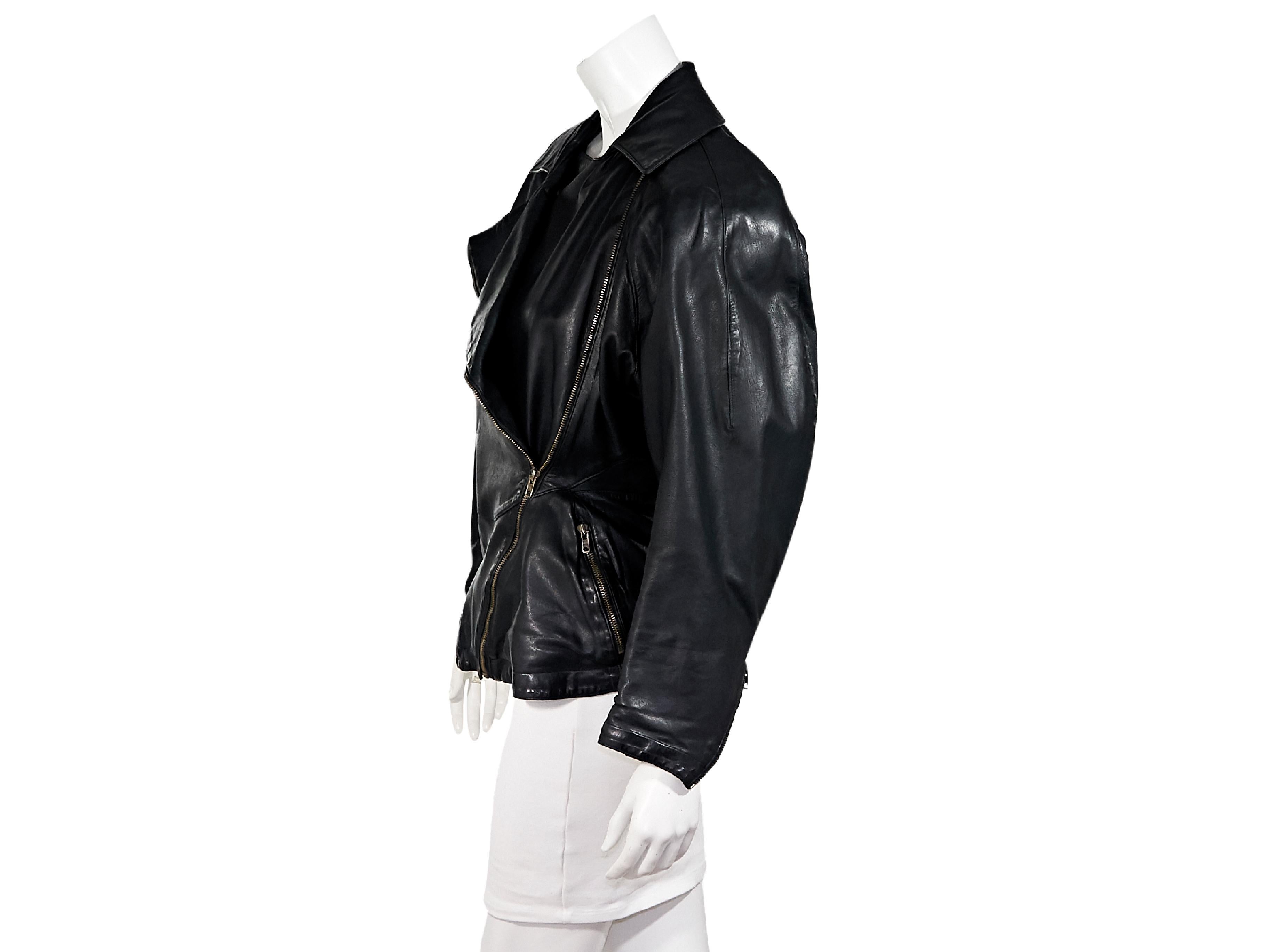 Product details:  Vintage black leather jacket by Alaia.  Circa the 1980s.  Long dolman sleeves.  Zip cuffs.  Asymmetrical zip-front closure.  Chest and waist zip-front pockets.  Goldtone hardware.  40