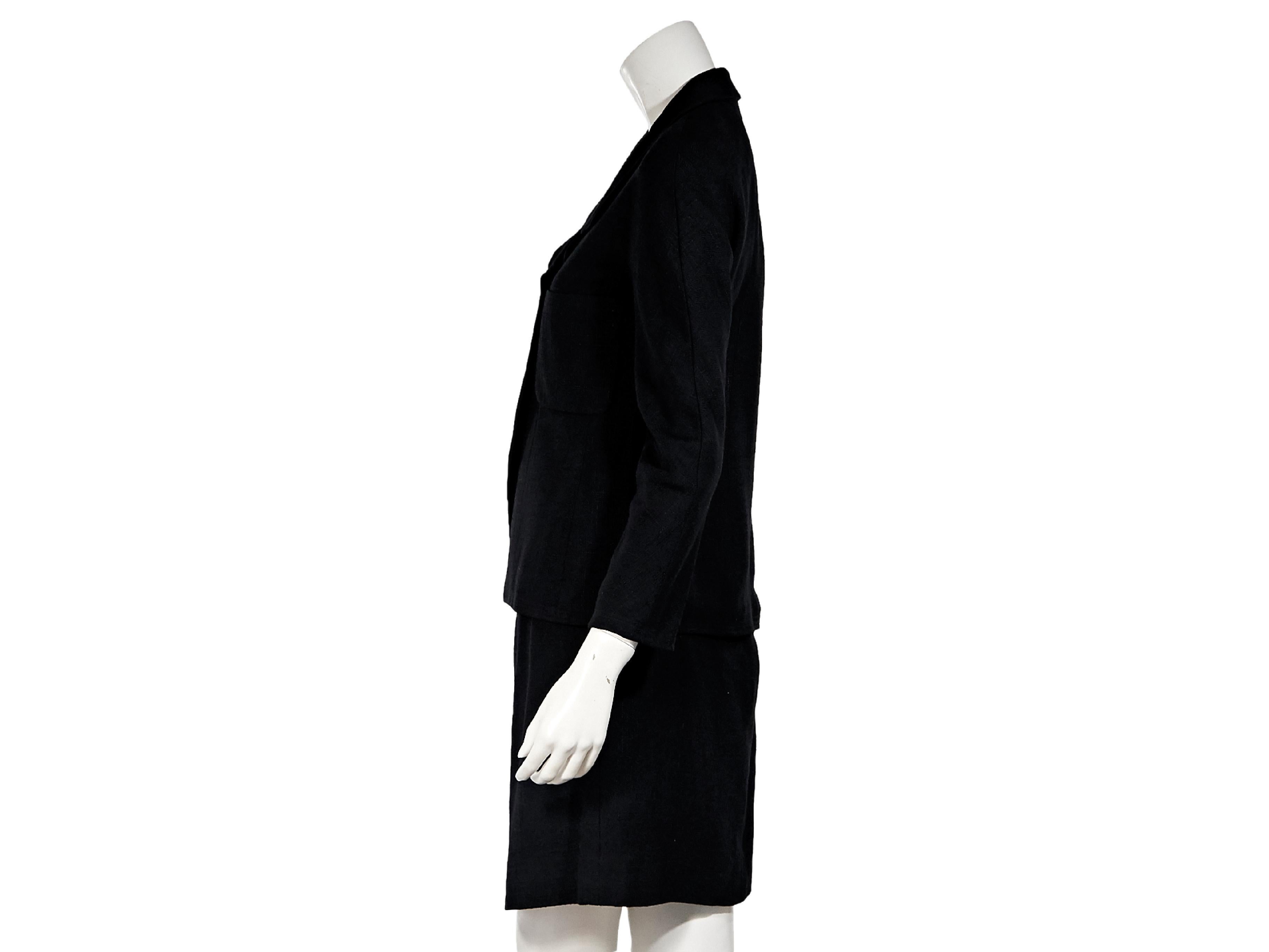 Product details:  Vintage black linen-blend skirt suit set by Chanel.  Rounded notched lapel.  Bracelet-length sleeves.  Double-breasted button-front closure.  Chest patch pockets.  Matching skirt.  Banded waist.  Goldtone hardware.  Jacket:  29