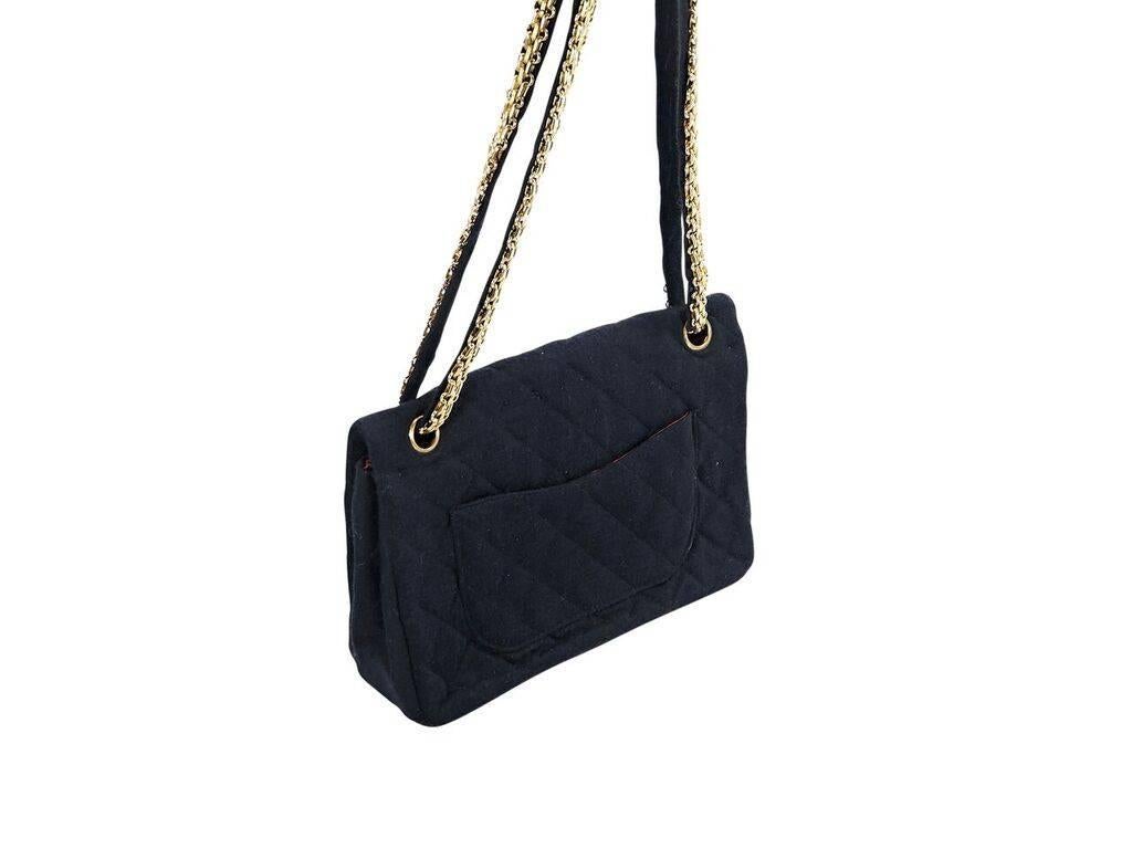 Product details:  Vintage black quilted jersey flap bag by Chanel.  Dual chain shoulder straps.  Front flap with twist-lock closure.  Zip and mirror flap pockets under front flap.  Lined interior with inner zip and slide pockets.  Goldtone hardware.