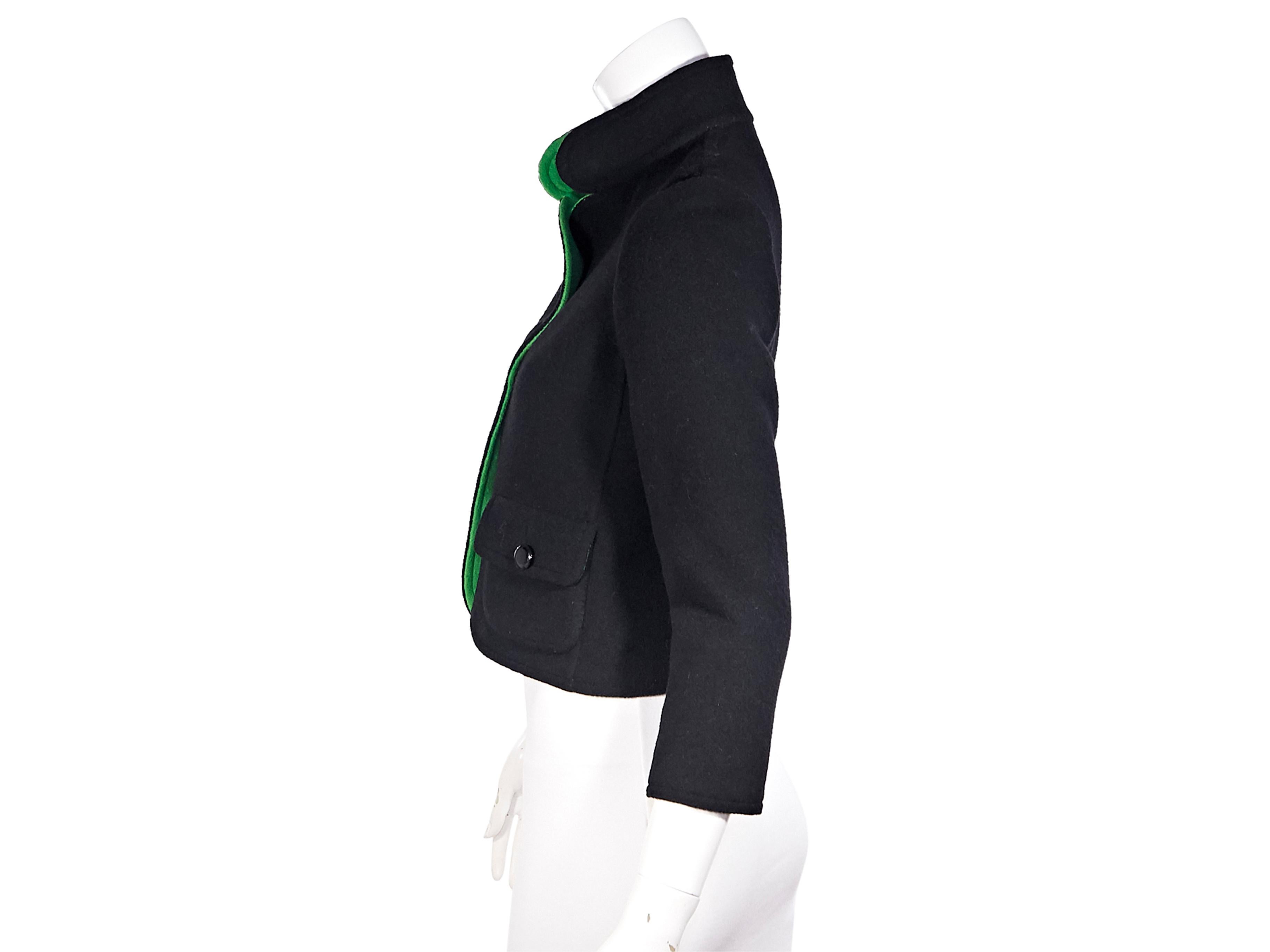 Product details:  Black wool jacket by Christian Dior Haute Couture.  From the FW 1972 collection.  Stand collar.  Long sleeves.  Button-front closure.  Waist button flap pockets.  32