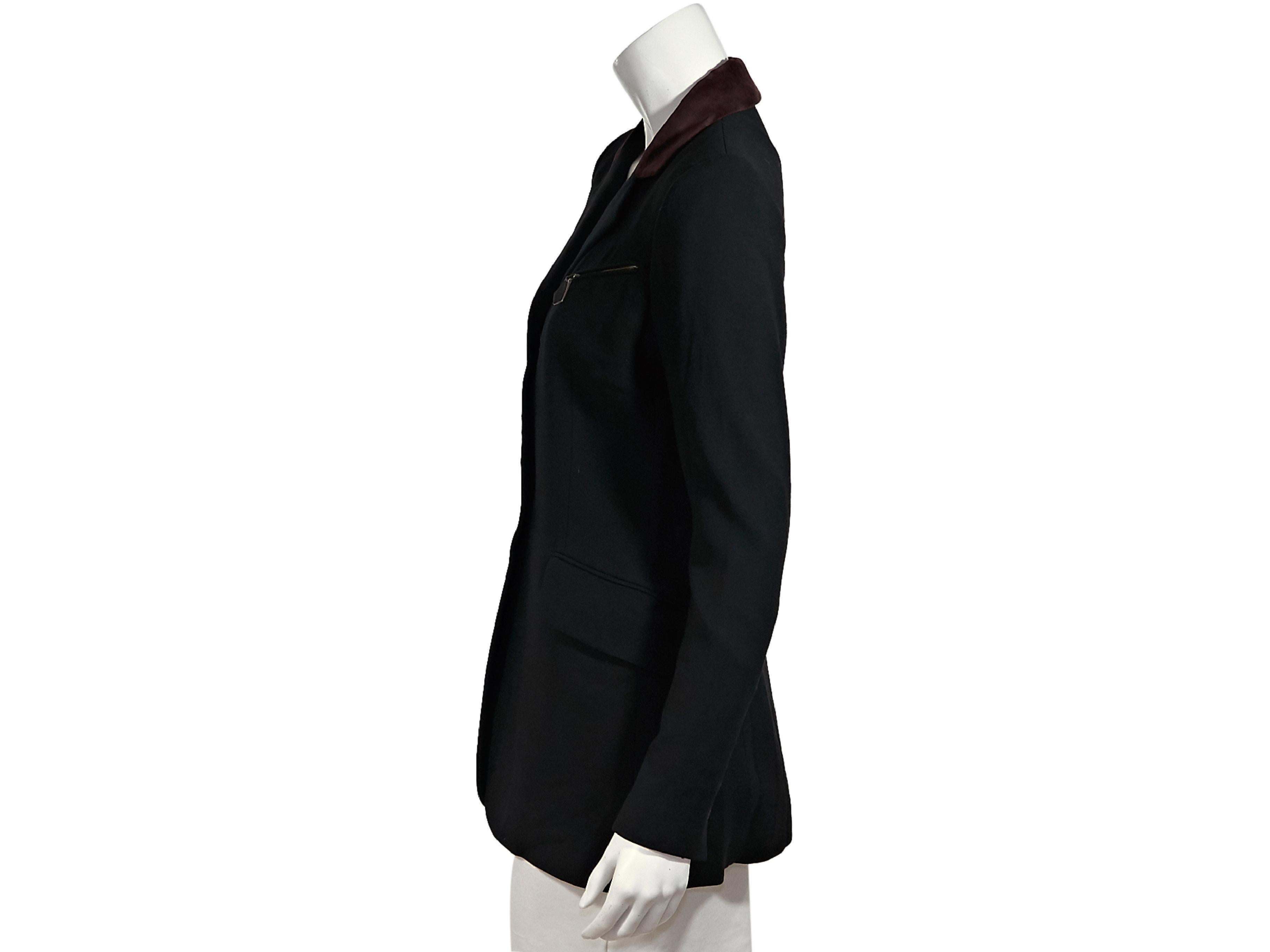 Product details:  Vintage black wool blazer by Hermes.  Burgundy velvet collar.  Notched lapel.  Long sleeves.  Three-button detail at cuffs.  Button-front closure.  Two zip pockets.  Waist flap pockets.  Back center hem vent with button details. 