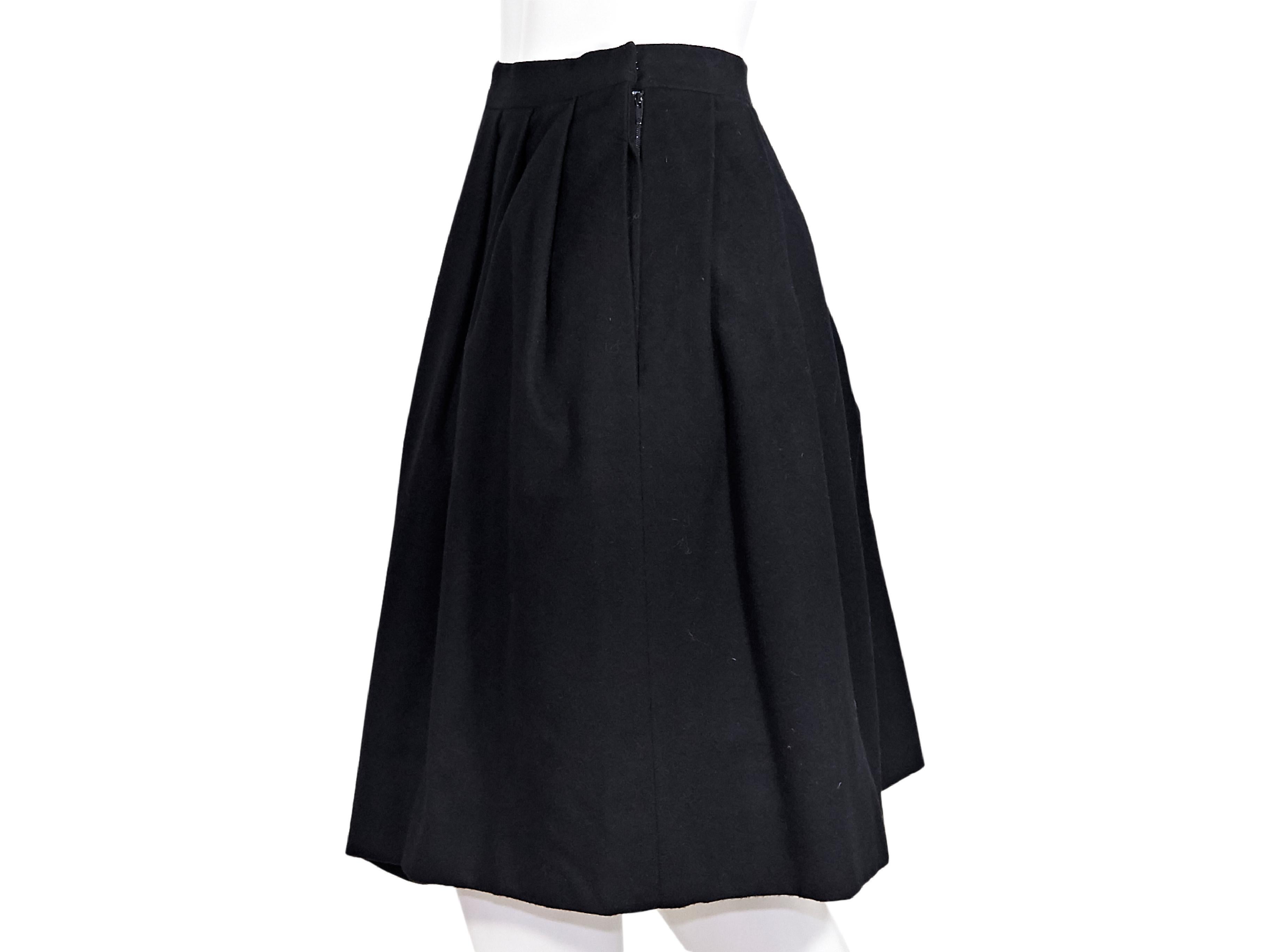 Product details:  Vintage black wool pleated skirt by Hermes.  Banded waist.  Concealed side zip closure.  Asymmetrical hem.  Label size FR 42.  30